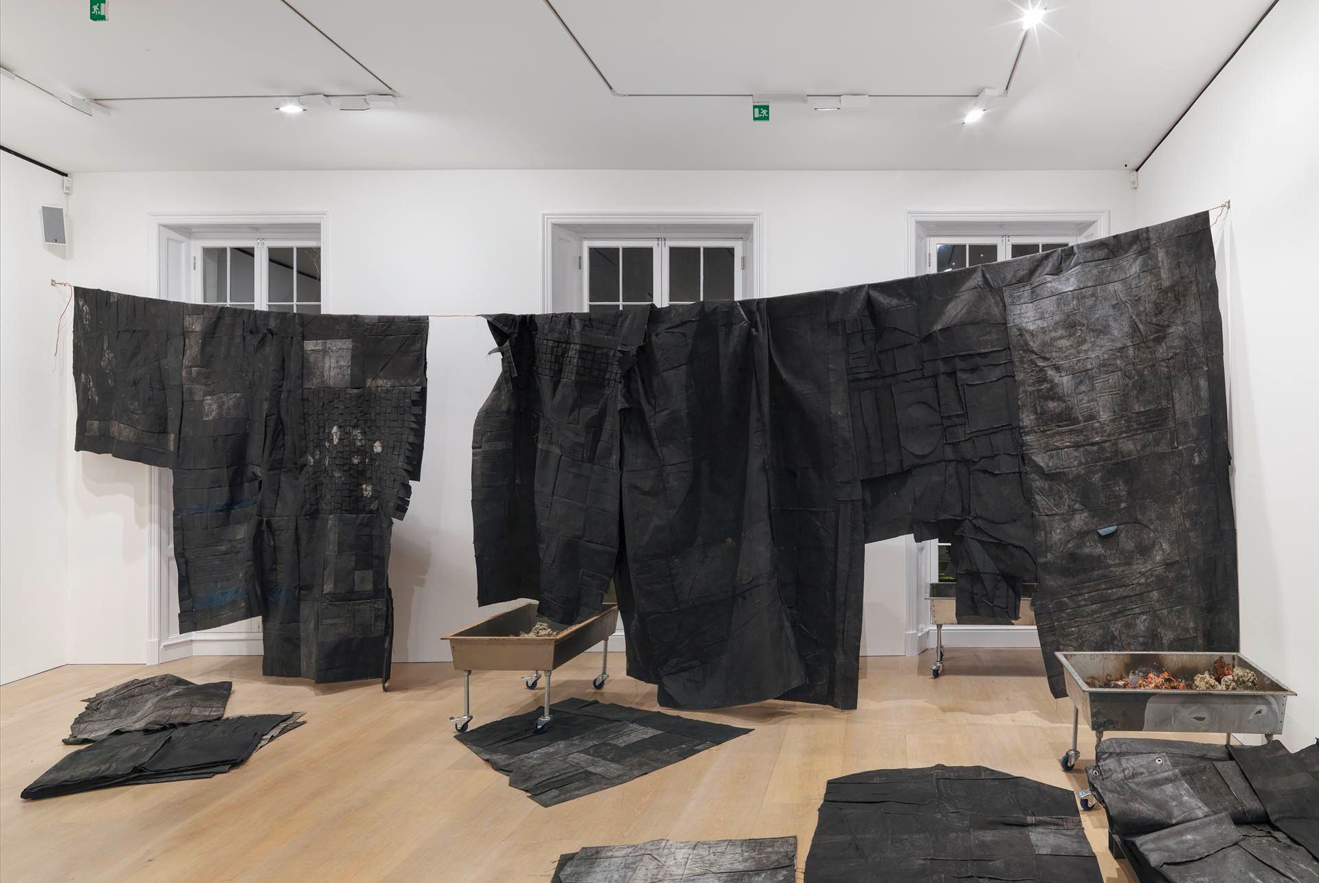 A painting by Oscar Murillo, titled meandering - black wall, dated 2014 to 2015.