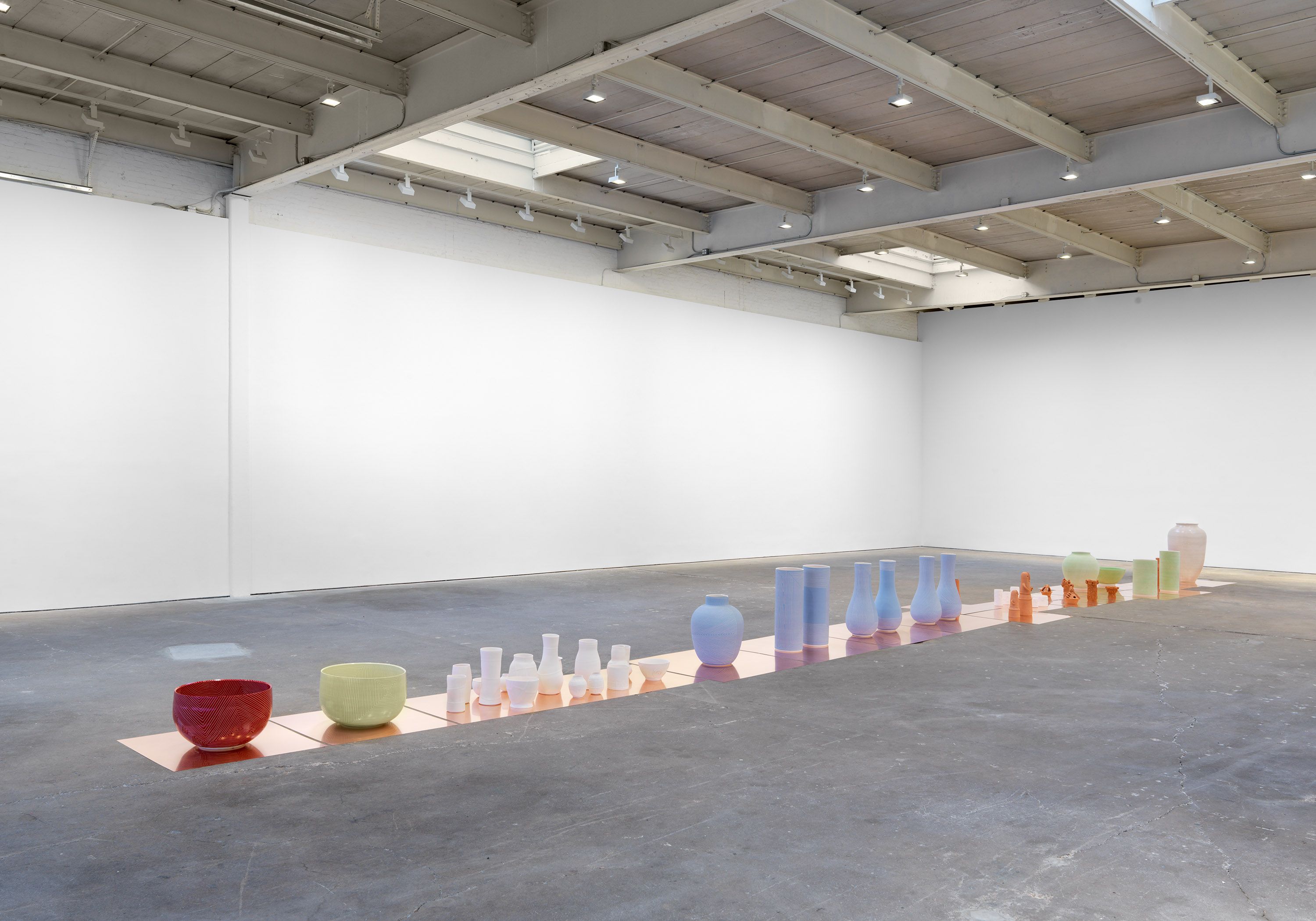 An installation consisting of twenty-three groupings of sculptures by Shio Kusaka, titled (one light year), dated 2022.