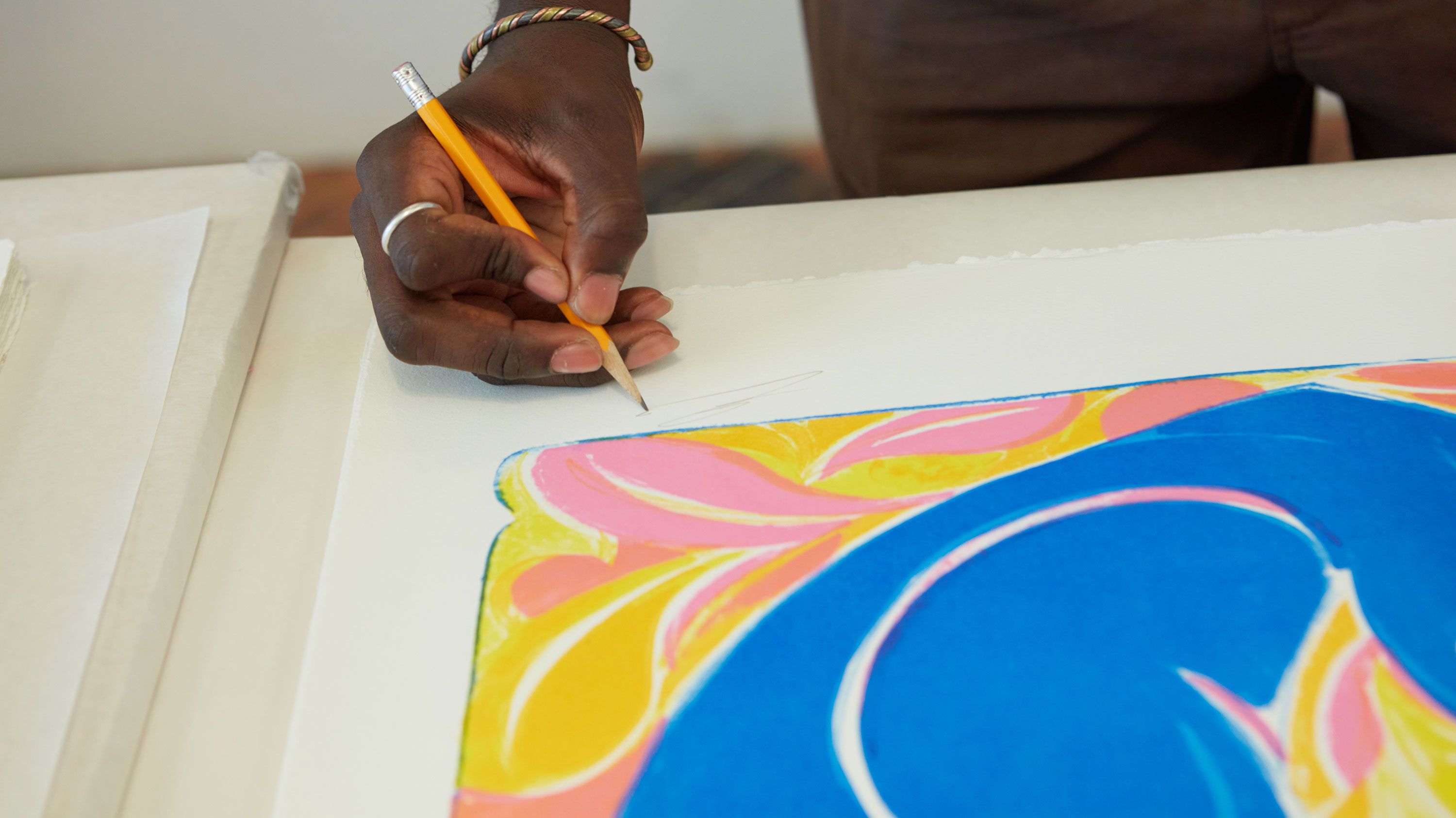 A photograph of Adeniyi-Jones signing his Sunrisers print at Jungle Press Editions. Photo by Rafael Rios