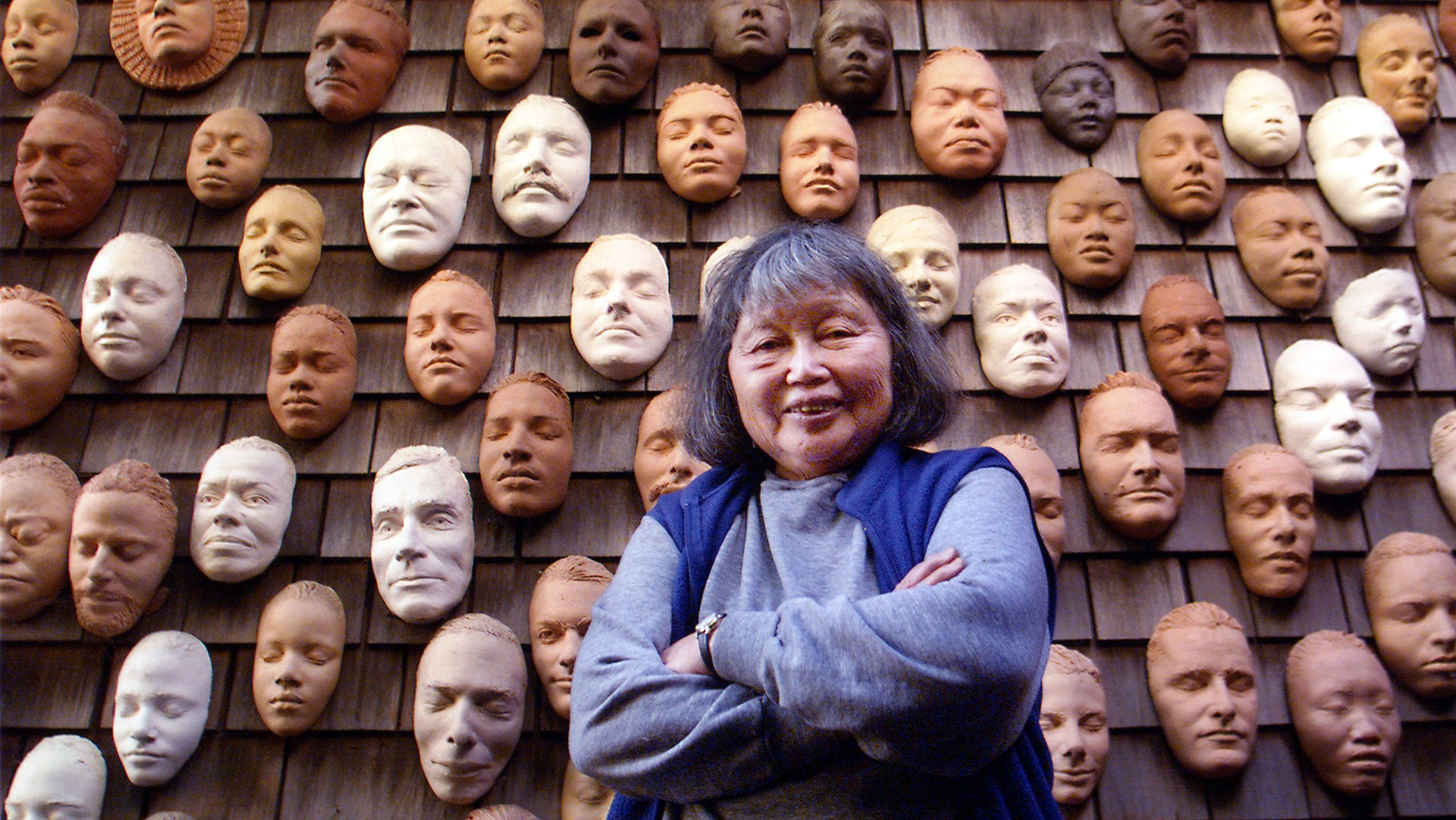 Ruth Asawa with life masks on the exterior wall of her house. Photo credit: Terry Schmitt / Estate of Ruth Asawa