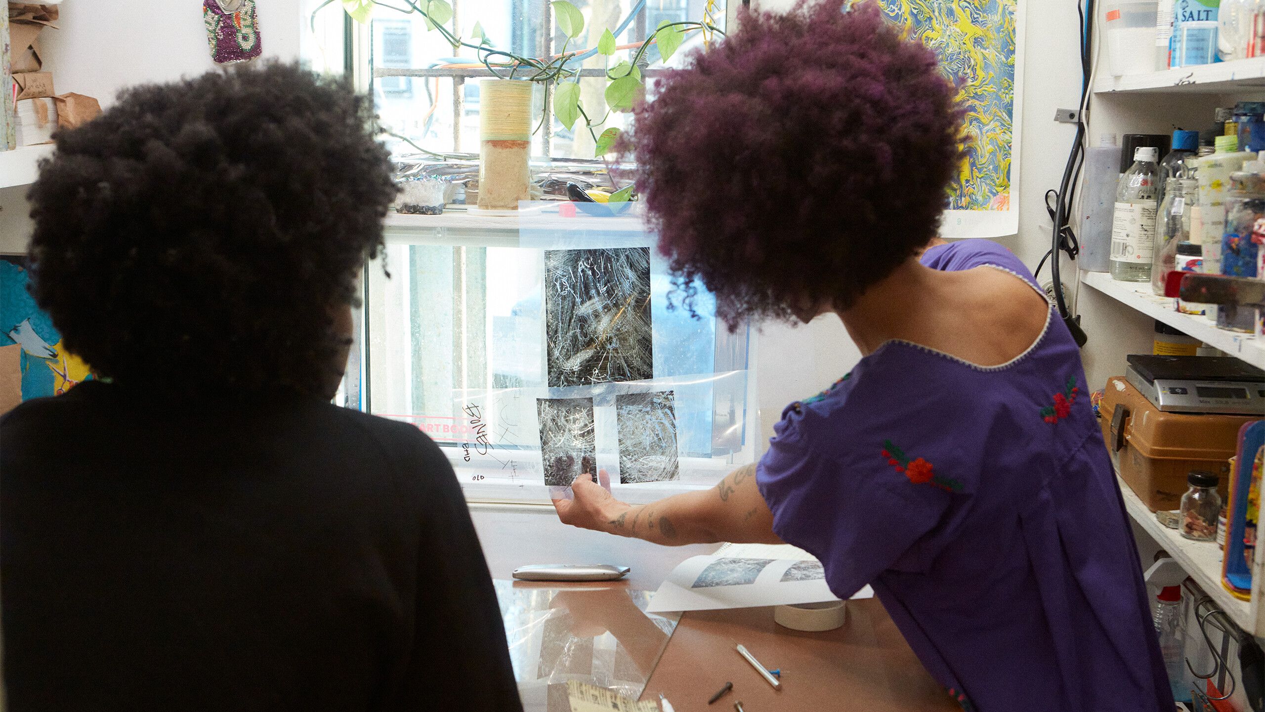 A photograph of Gale and Diuguid reviewing Gale’s films by Rafael Rios, dated 2022.