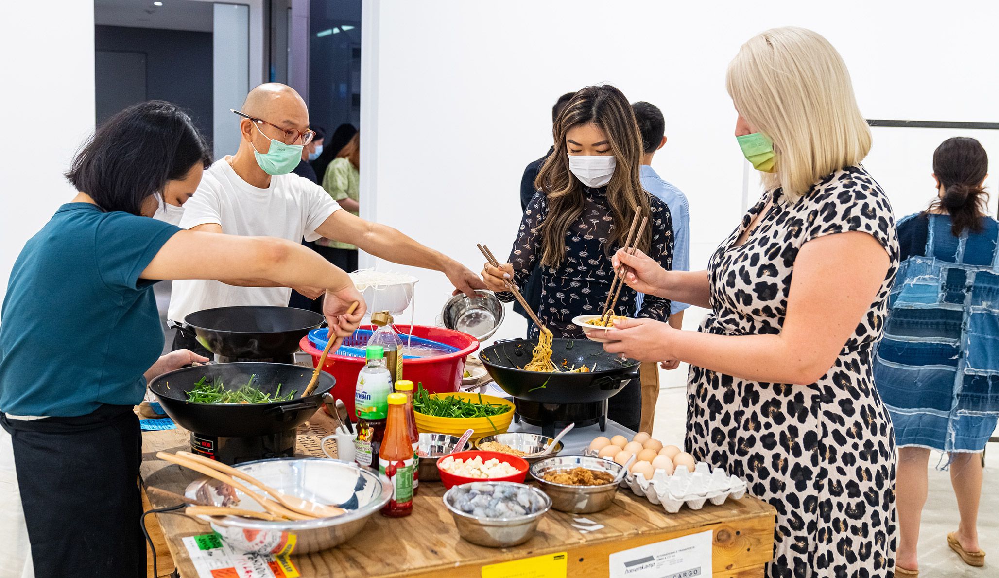 A photo of a reenactment of a work by Rirkrit Tiravanija, called untitled 1990 (pad thai), dated 1990.