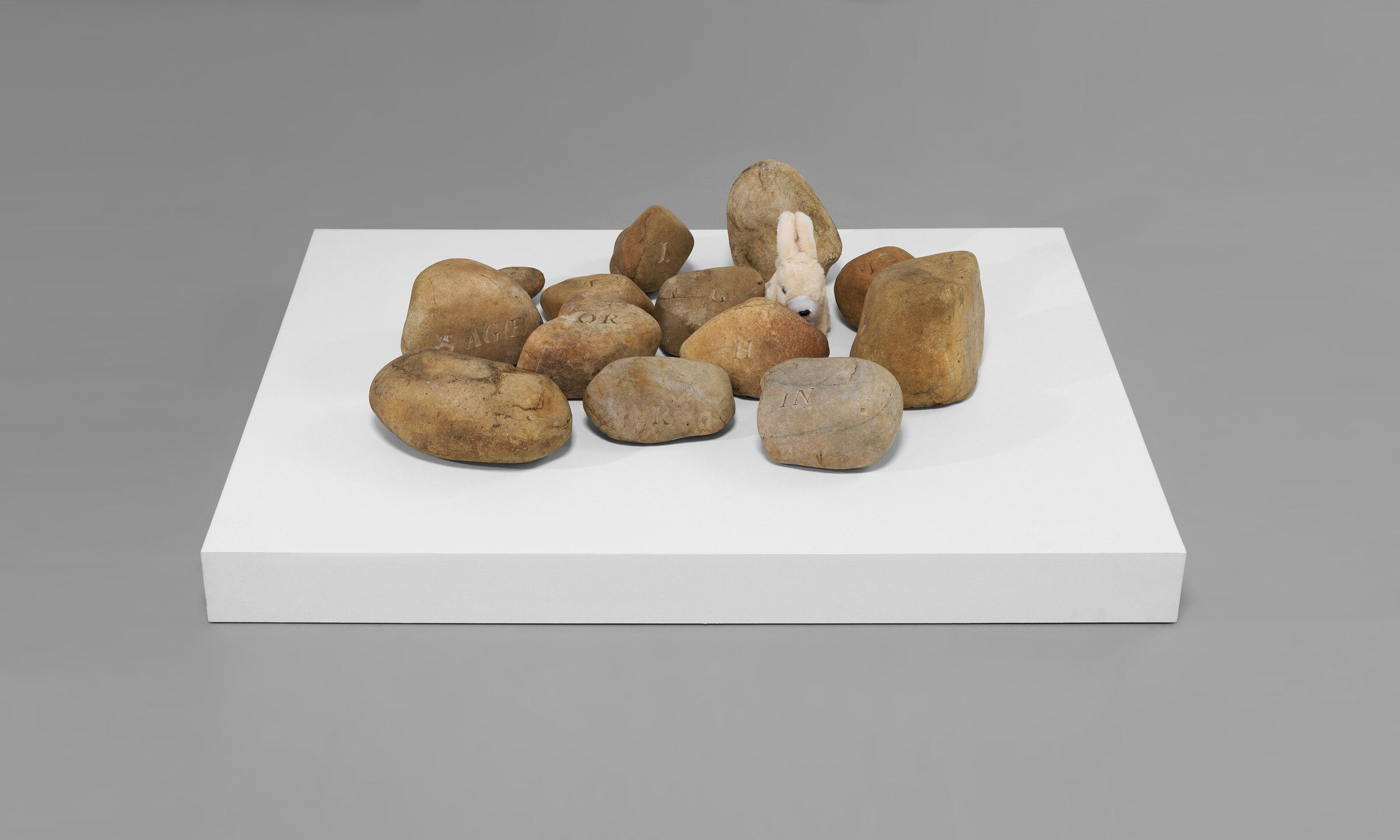 A work by Geoffrey Hendricks, titled 13 Stones for Ray with mechanical bunny, dated 2001.