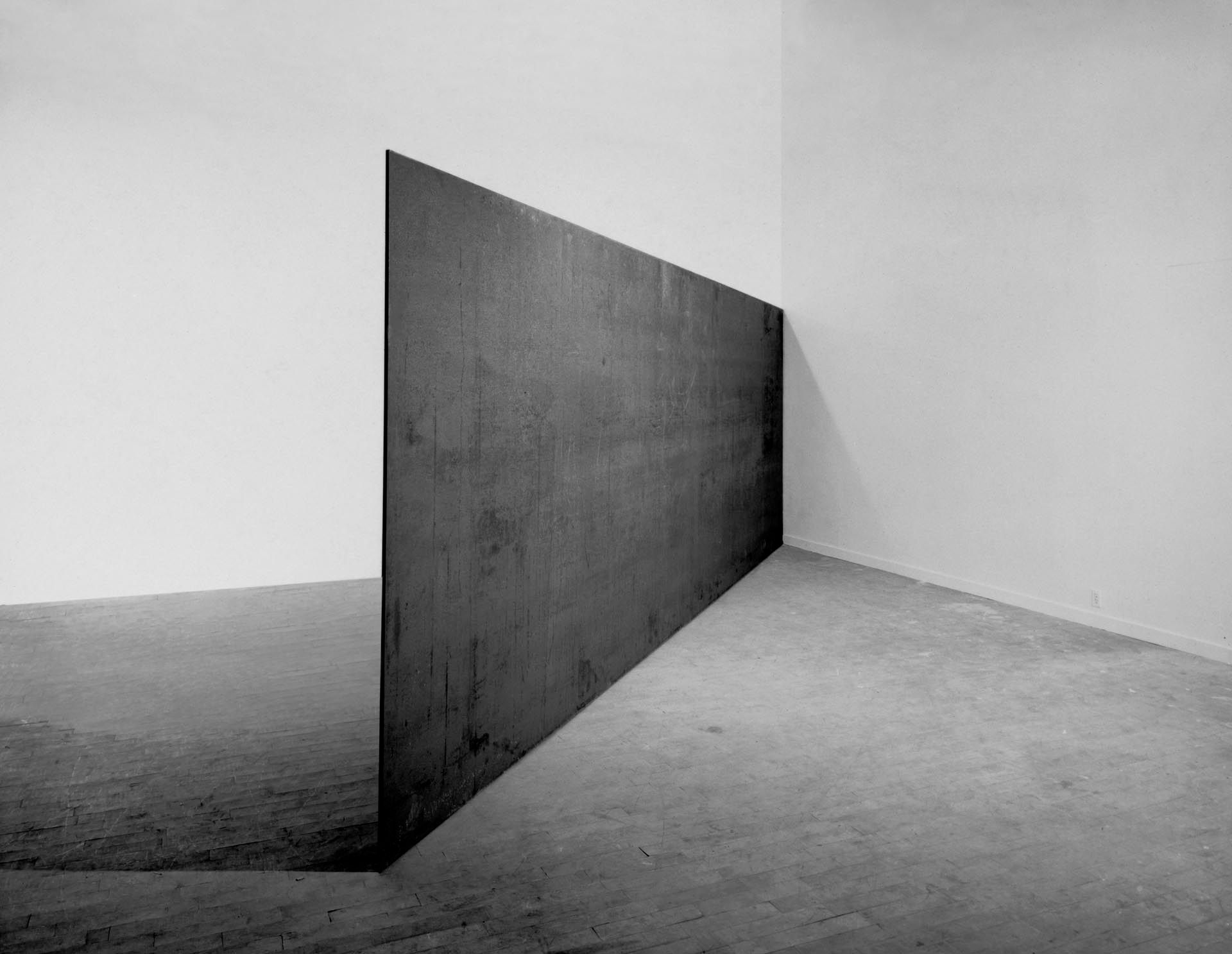 A hot-rolled steel sculpture by Richard Serra titled Strike: To Roberta and Rudy, dated 1969-1971..