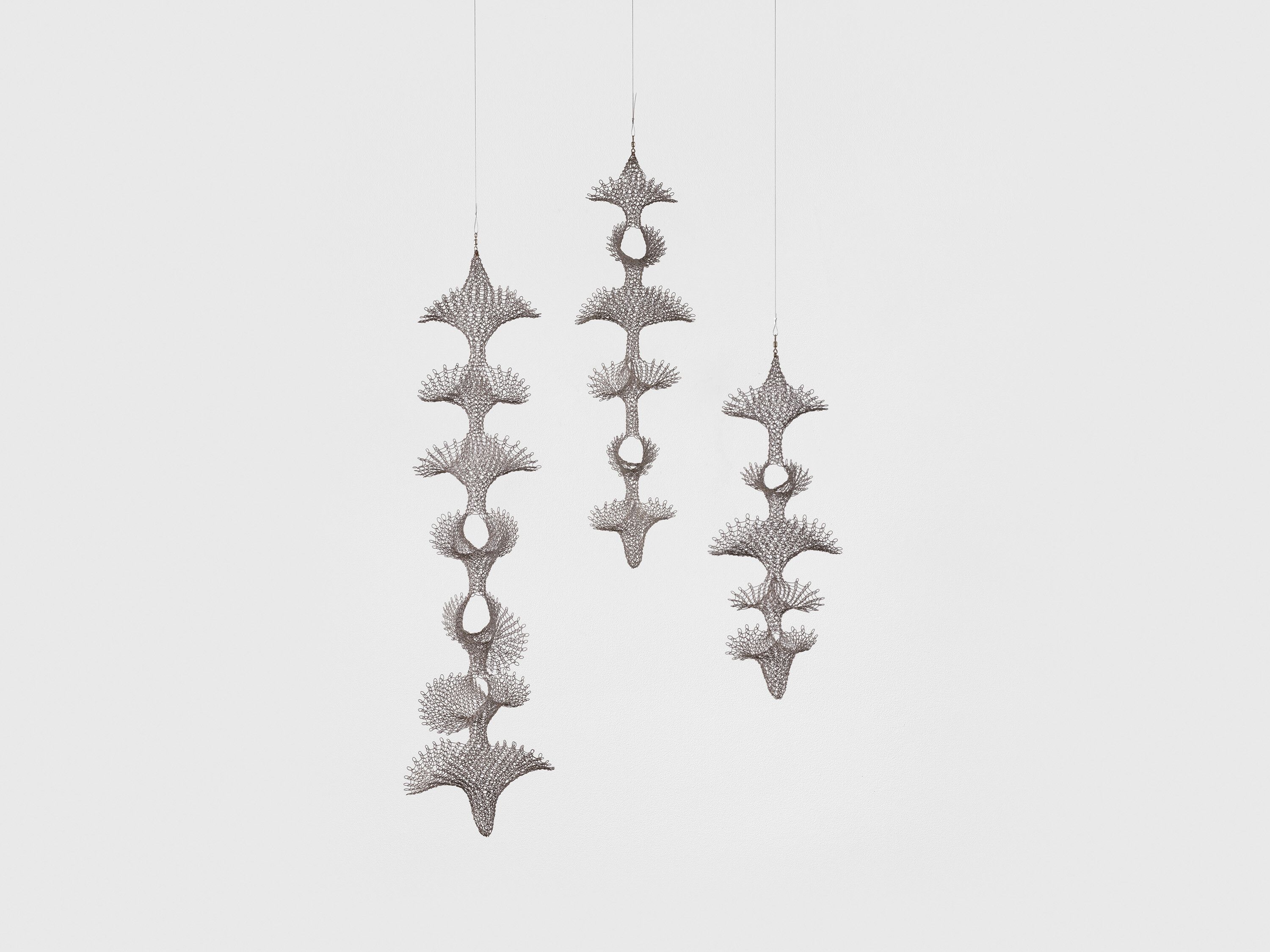 A hanging sculpture—sterling silver wire artwork by Ruth Asawa, titled Untitled (S.633(a-c), Trio of Hanging Reversible, Open-Window Form Sculptures), circa 1956.