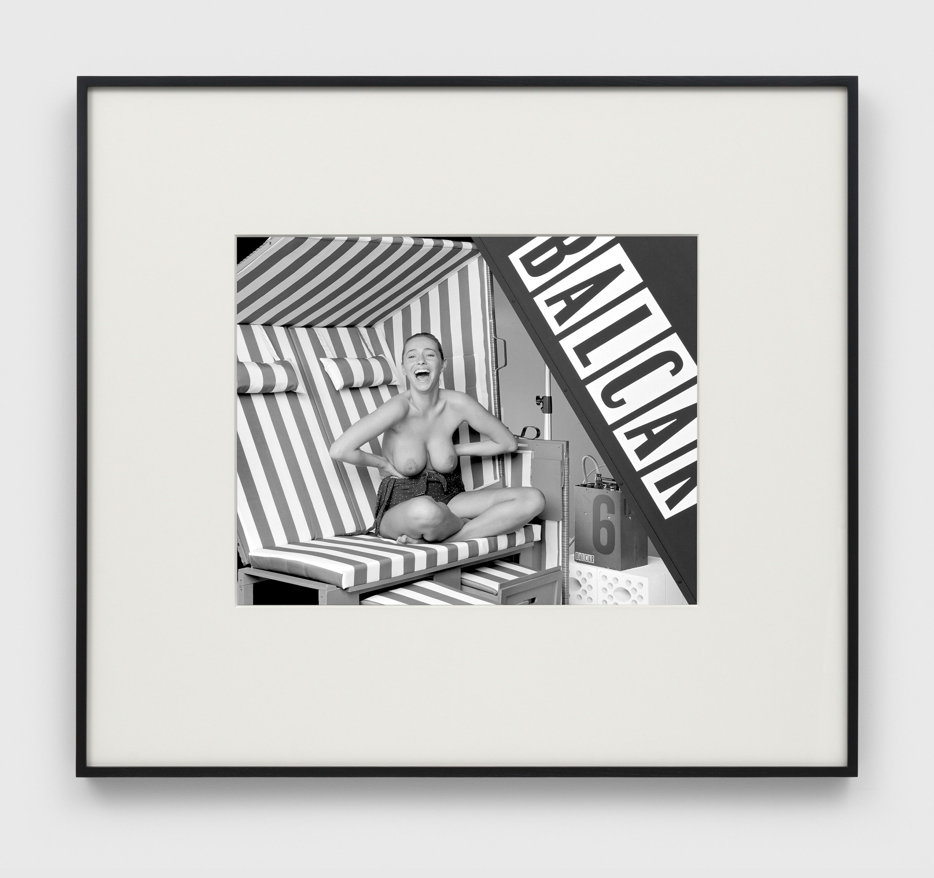 A photograph by Christopher Williams, titled TecTake Luxus Strandkorb grau/weiß  Model no.: 400636  Material: wood/plastic  Dimensions (height/width/depth): 154 cm × 116 cm × 77 cm   Weight: 49 kg  Manufactured by Ningbo Jin Mao Import & Export Co., Ltd, Ningbo, Zhejiang, China for TecTake GmbH, Igersheim, Germany  Model: Zimra Geurts, Playboy Netherlands Playmate of the Year 2012  Studio Rhein Verlag, Düsseldorf  February 1, 2013  (Zimra stretching), dated 2013. 