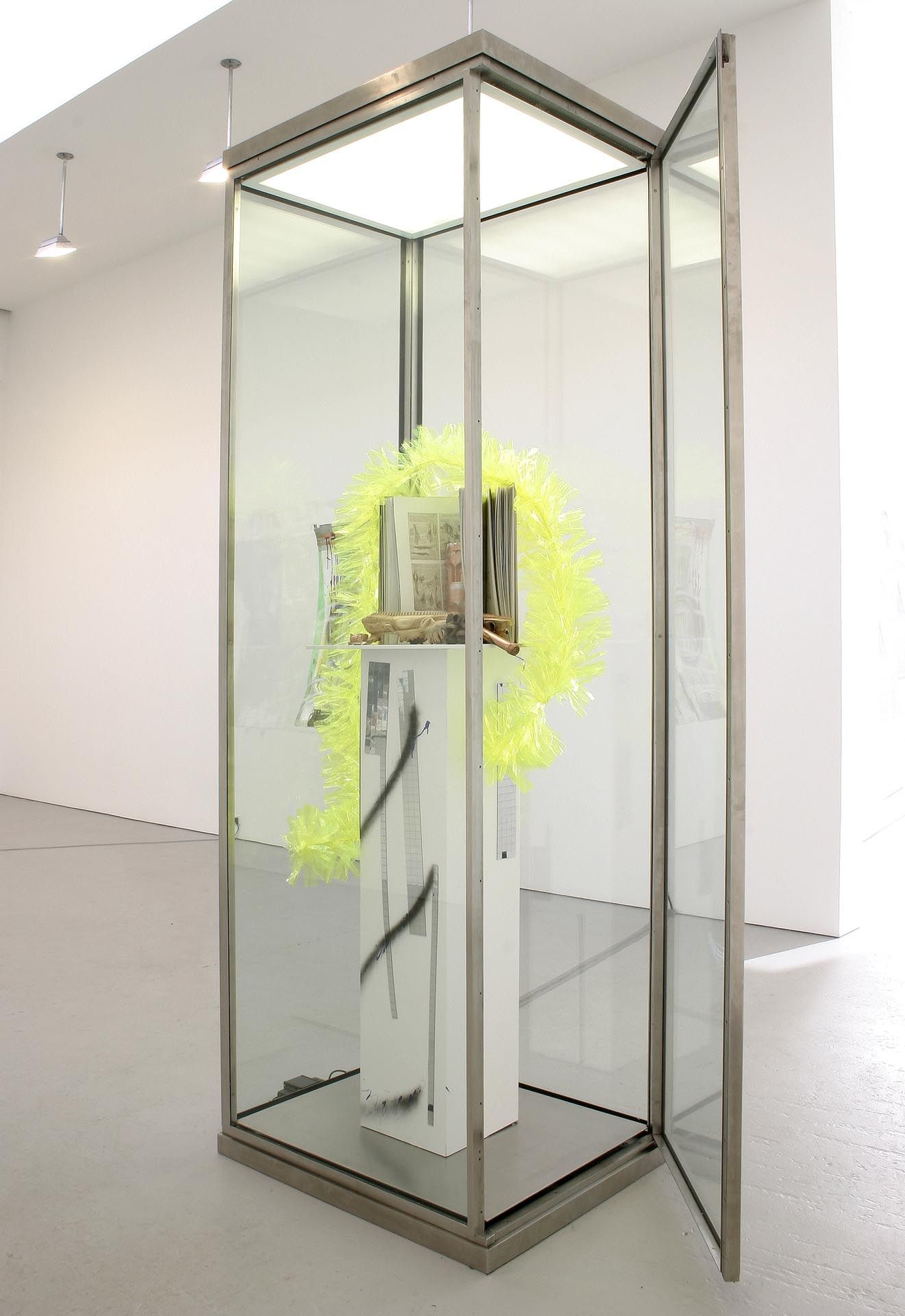 A sculpture by Isa Genzken, titled Vitrine mit gelber Plasikboa, dated 2004.