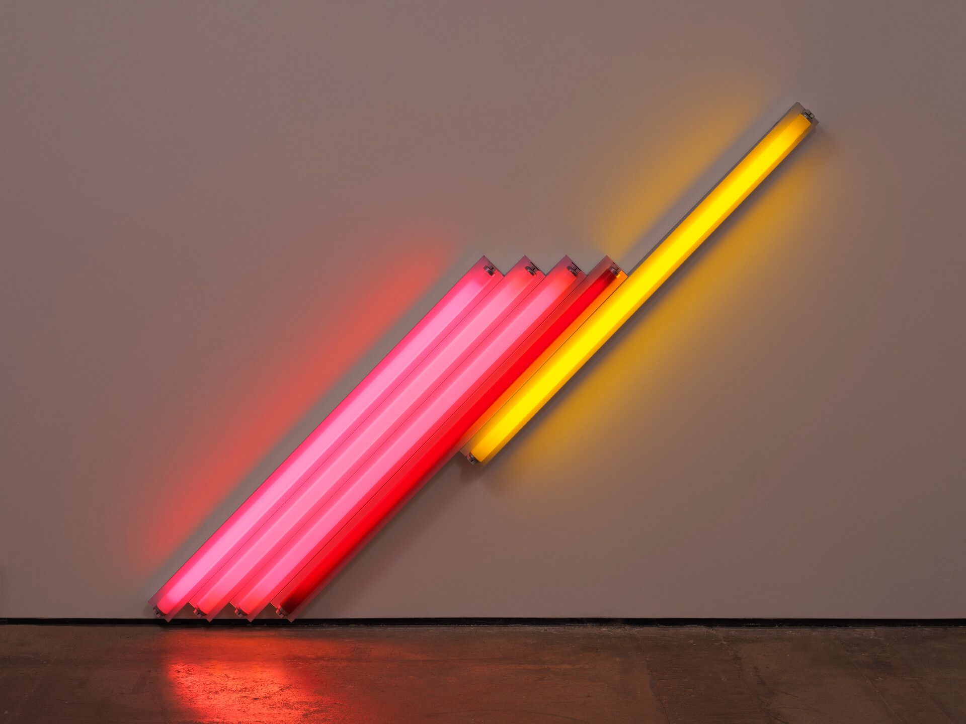 A pink, red, and yellow fluorescent light sculpture by Dan Flavin, titled untitled (for Frederika and Ian) 2, dated 1987. 