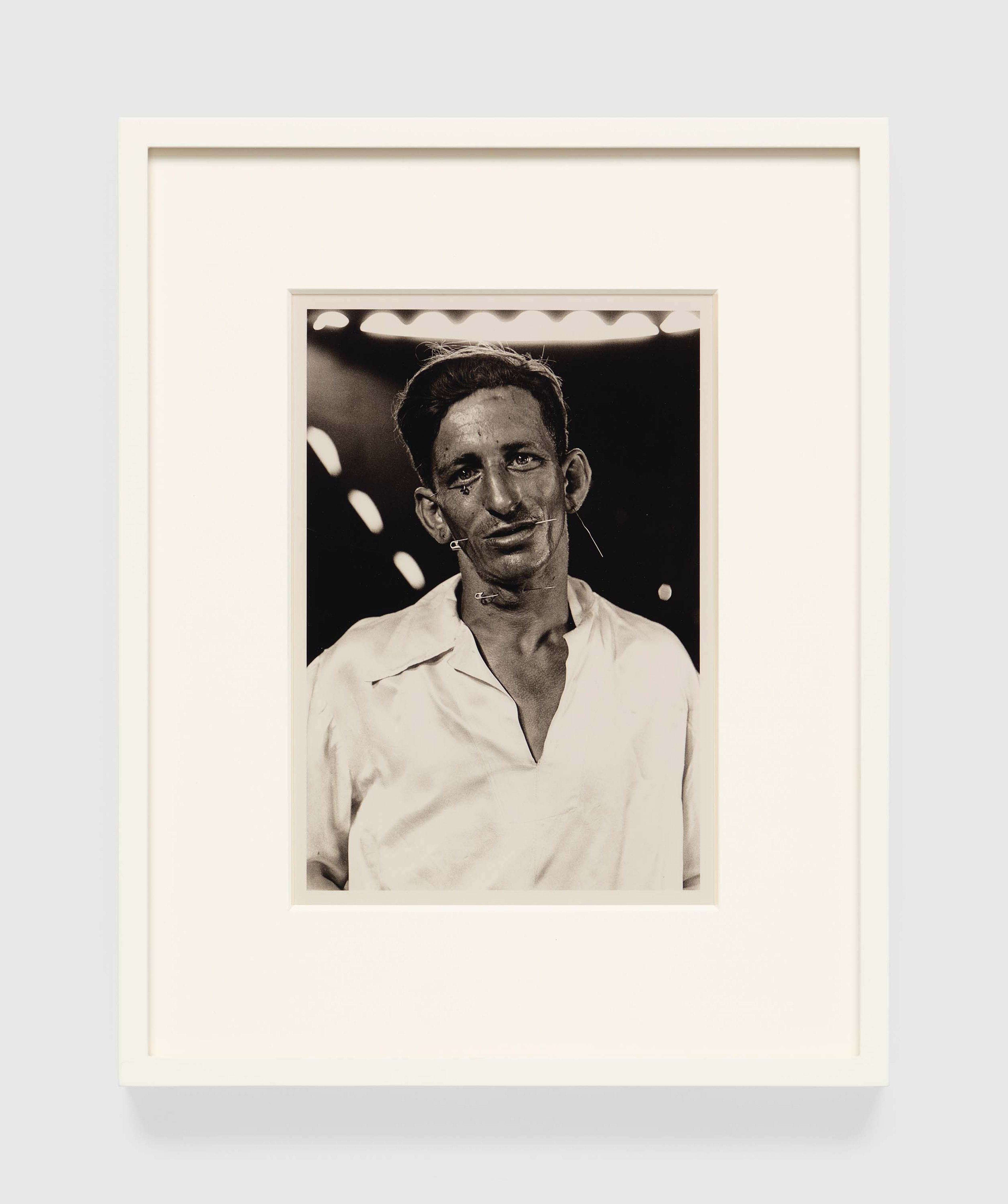 A photograph by Diane Arbus, titled The Human Pincushion, Louis Ciervo, in his silk shirt, Hagerstown, Md. 1961, dated 1961.