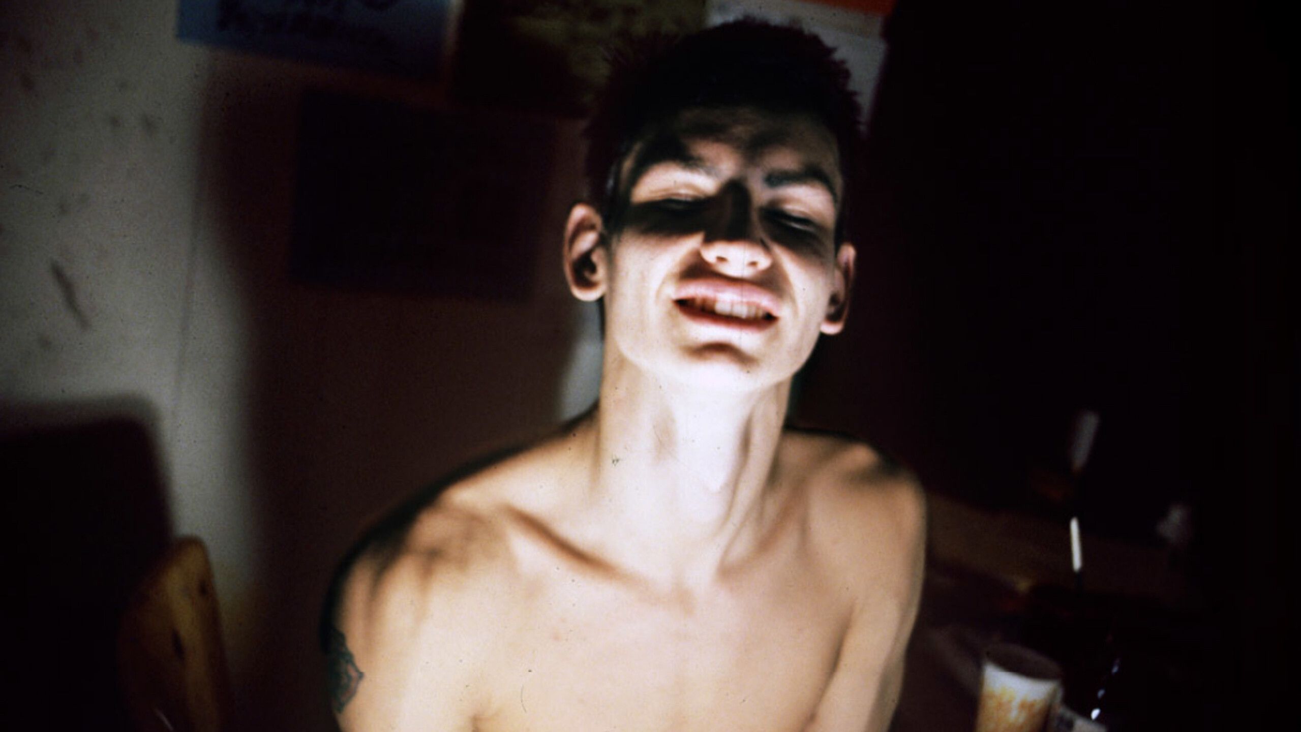 A photo by Gail Thacker titled Mark Morrisroe, Eyes Closed (Pat’s Room on Day Tripper, Boston to NYC), dated 1980/81.