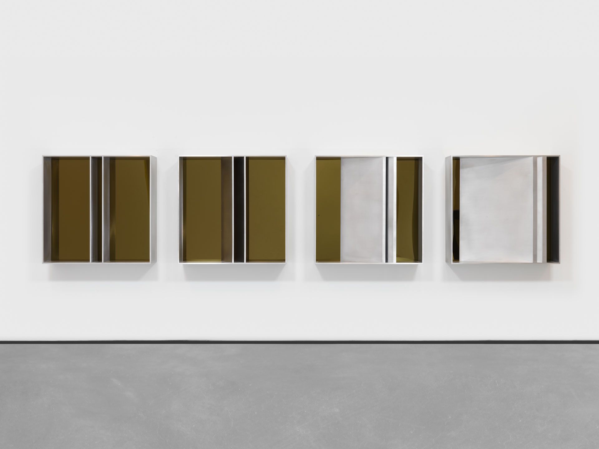 An untitled brushed aluminum and yellow over blue acrylic sheet sculpture comprised of four units by Donald Judd, dated 1982.