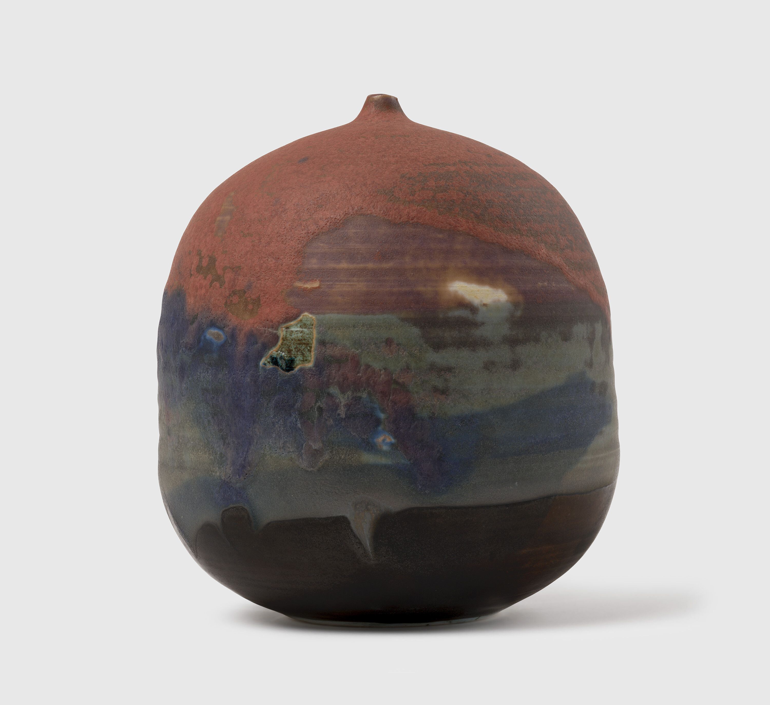A sculpture by Toshiko Takaezu, called Untitled Cranberry Red, Purple, and Blue Closed Form, circa 1990.