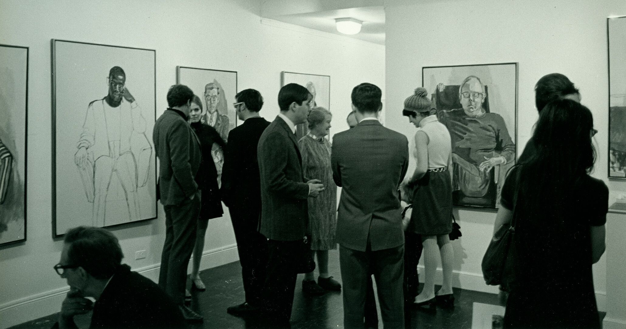 A photo of Alice Neel (at center) with Hartley (left) and Richard (back to camera) at the opening of her solo exhibition at the Graham Gallery c.1968.