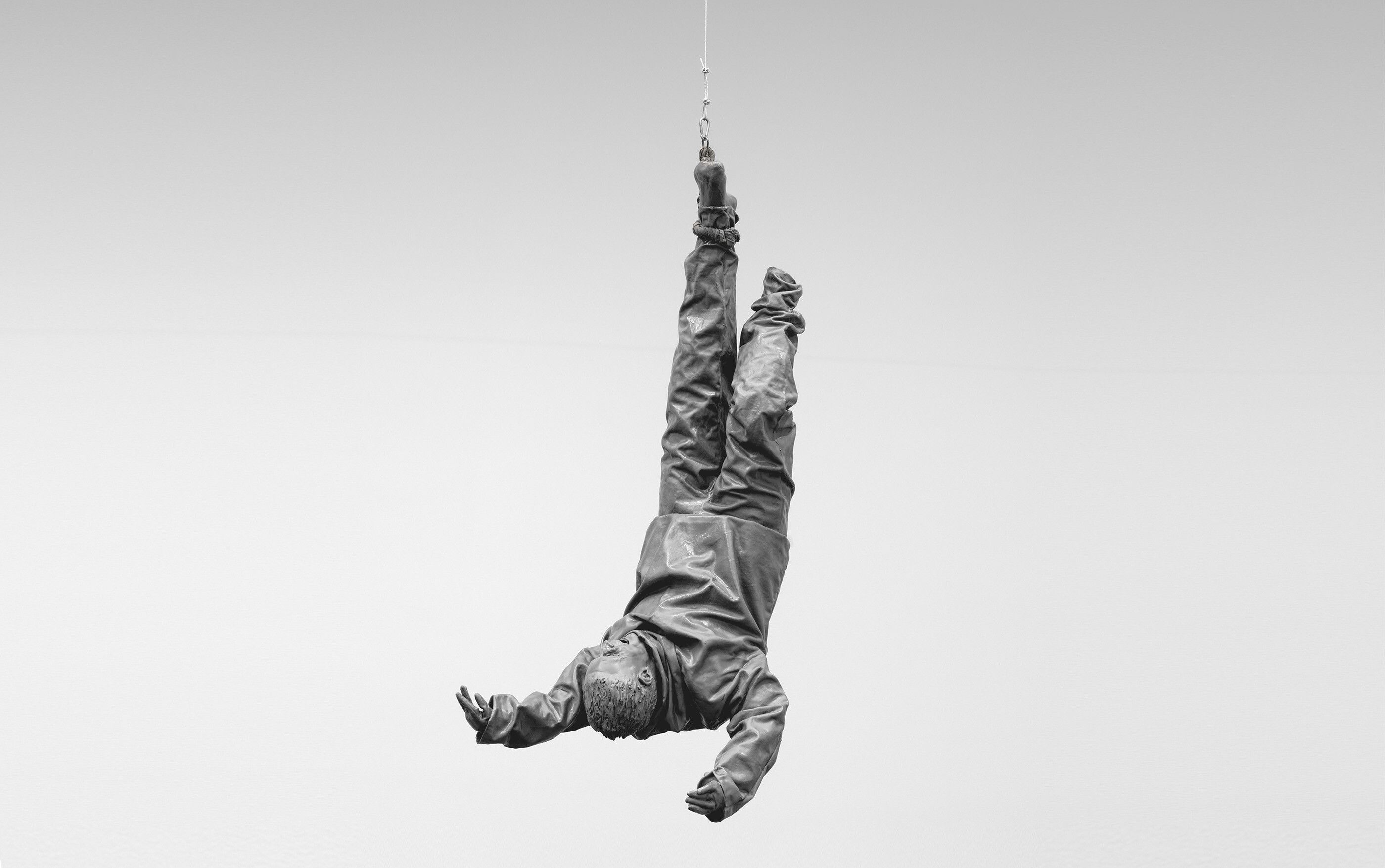 A suspended sculpture by Juan Muñoz, titled Figure Hanging from One Foot, dated 2001.