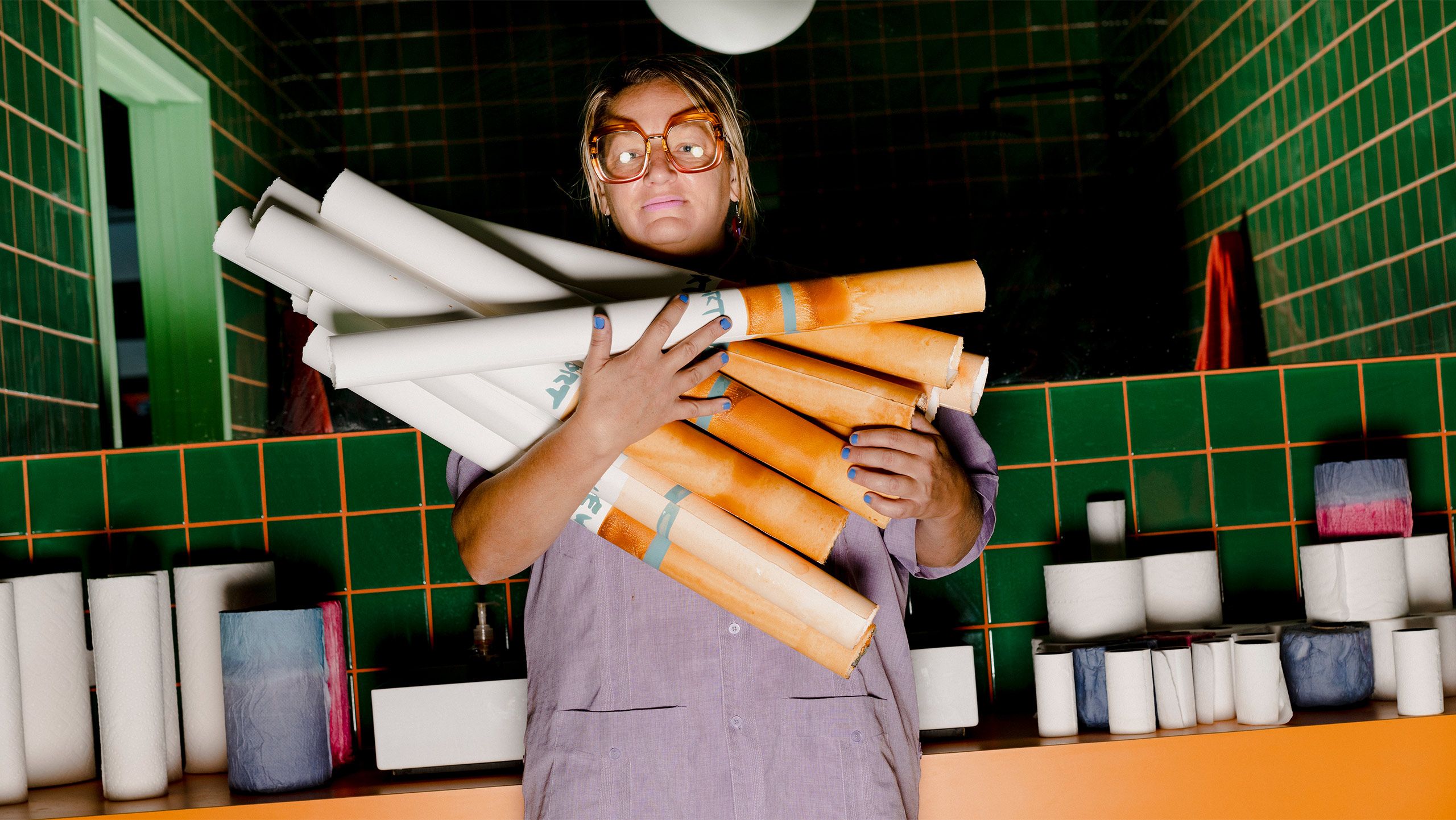 A Photo by Lyndon French of Bernhardt designed the green shower with orange grout for her studio in St. Louis, a six-thousand-square-foot warehouse and former auto shop that she fully revamped after returning to her hometown in 2019. 