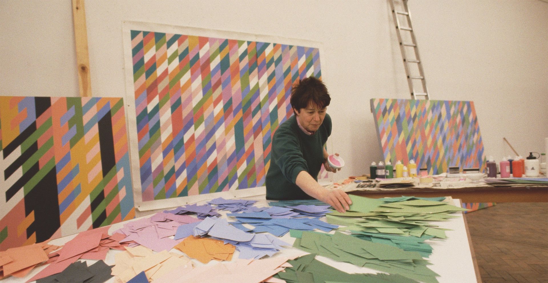 A photo of Bridget Riley in her East London studio with cartoon scale pieces, early 1990s.