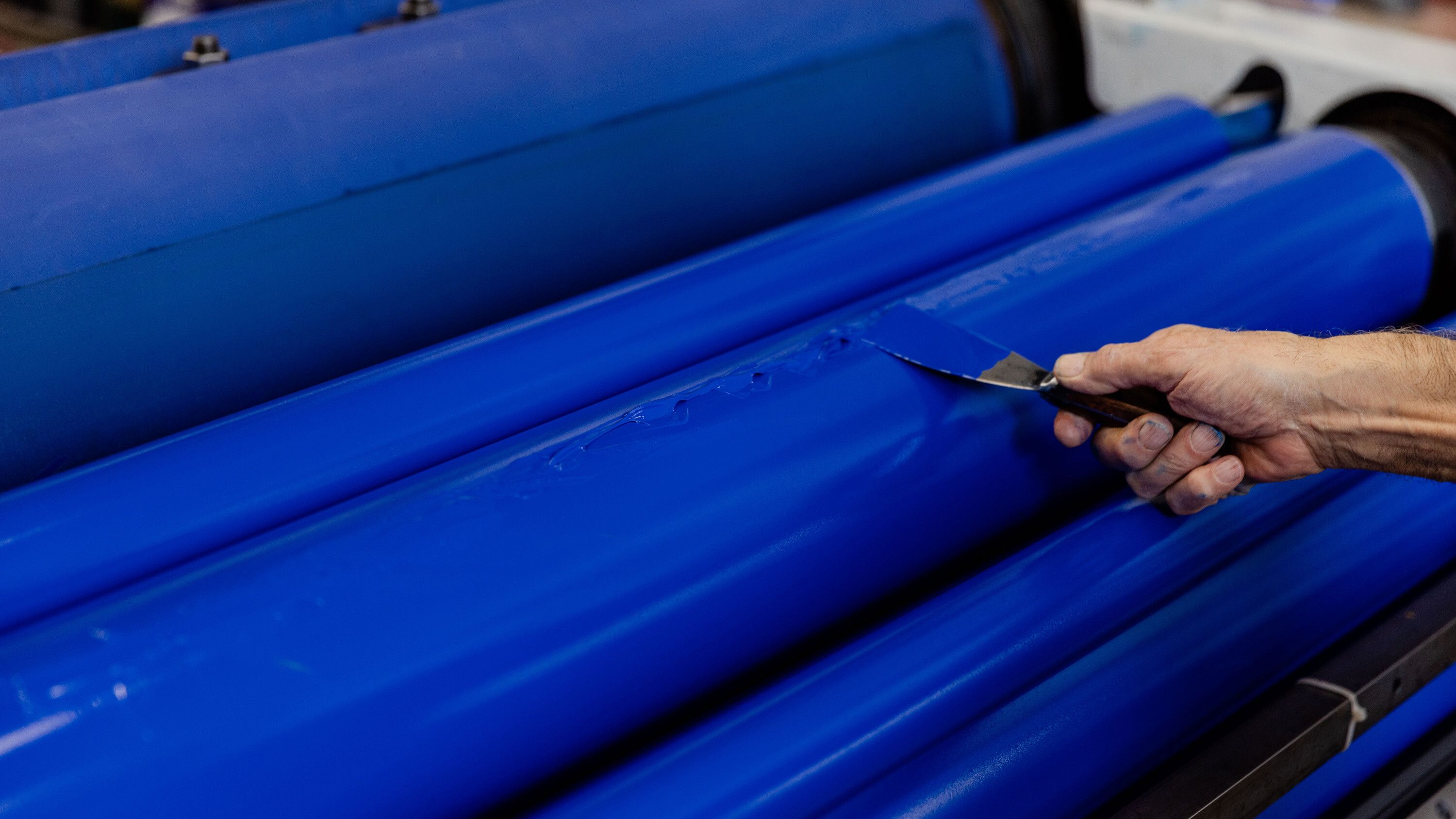 The rollers of an offset lithographic press are inked to pull an impression of Untitled (Our Secret Spot.). Photo by Max Burkhalter