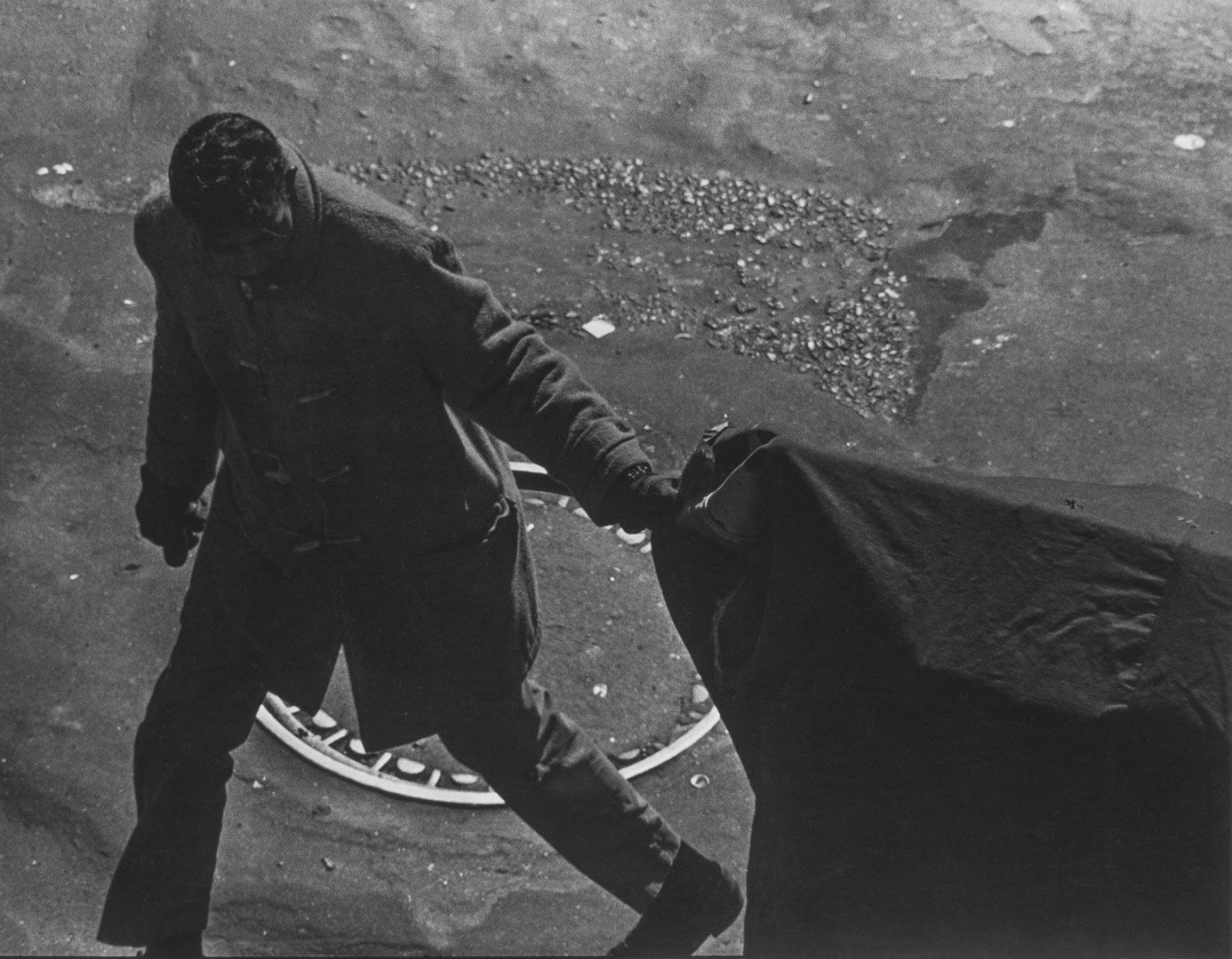 A photograph by Roy DeCarava, titled Garment worker, covered cart, dated 1962.