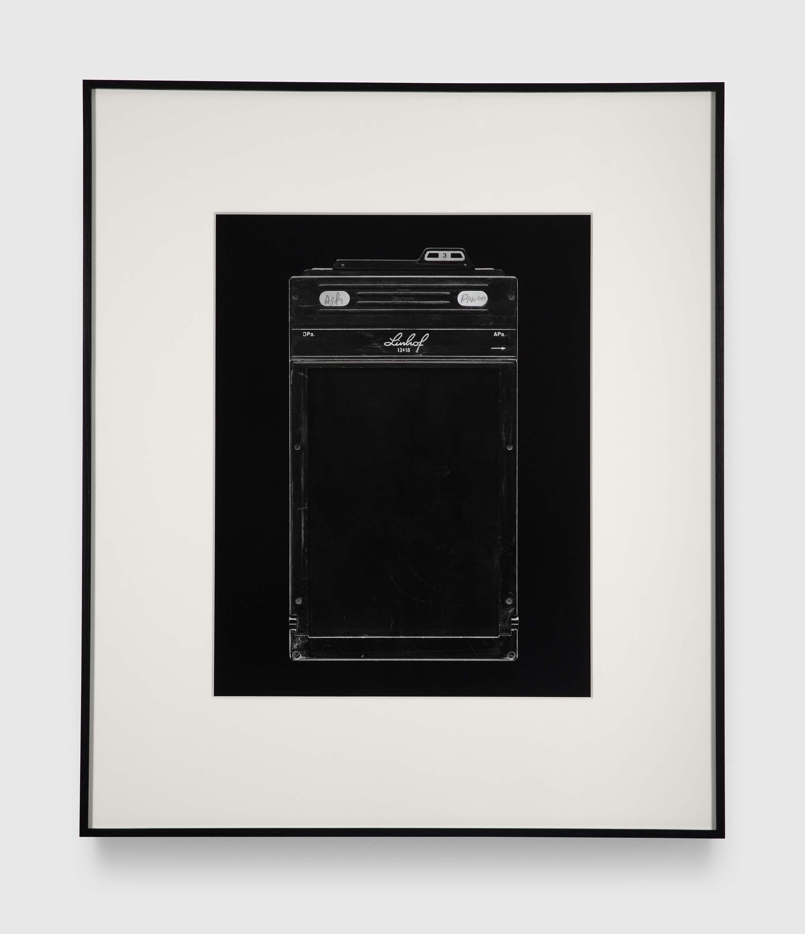 A photograph by Christopher Williams, titled Linhof 13x18 DPa. APa. Doppelkassette / Double Plate and Cutfilm Holder / Châssis Double / Chasis Double - YZDD - Manufactured by Linhof, Nikolaus Karpf K.G., Präzisions-Kamera-Werke, München 25, West-Germany Studio Rhein Verlag, Düsseldorf January 15, 2016, dated 2016.