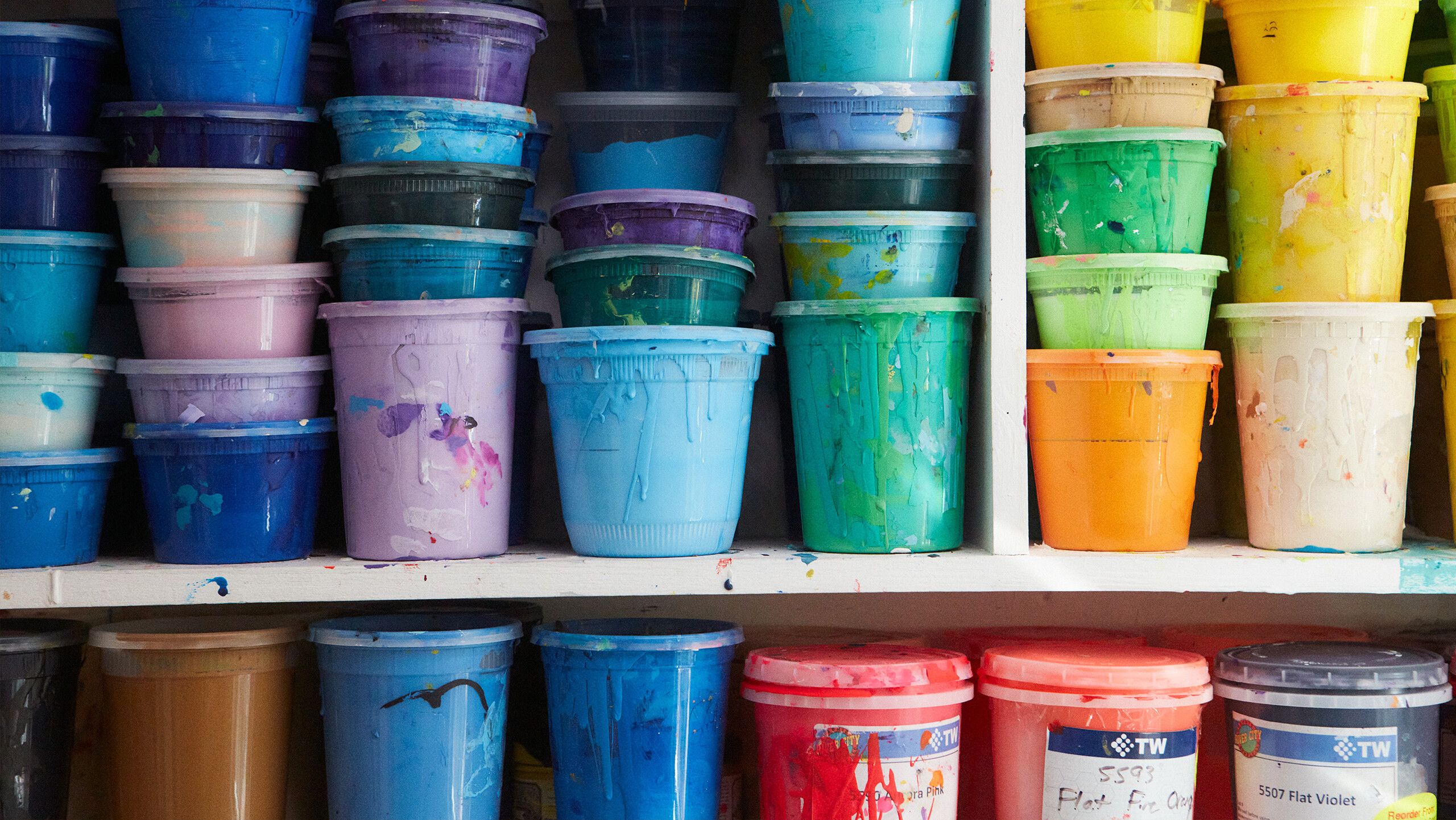 A photograph of screenprinting ink shelved away in the studio by Rafael Rios, dated 2022.