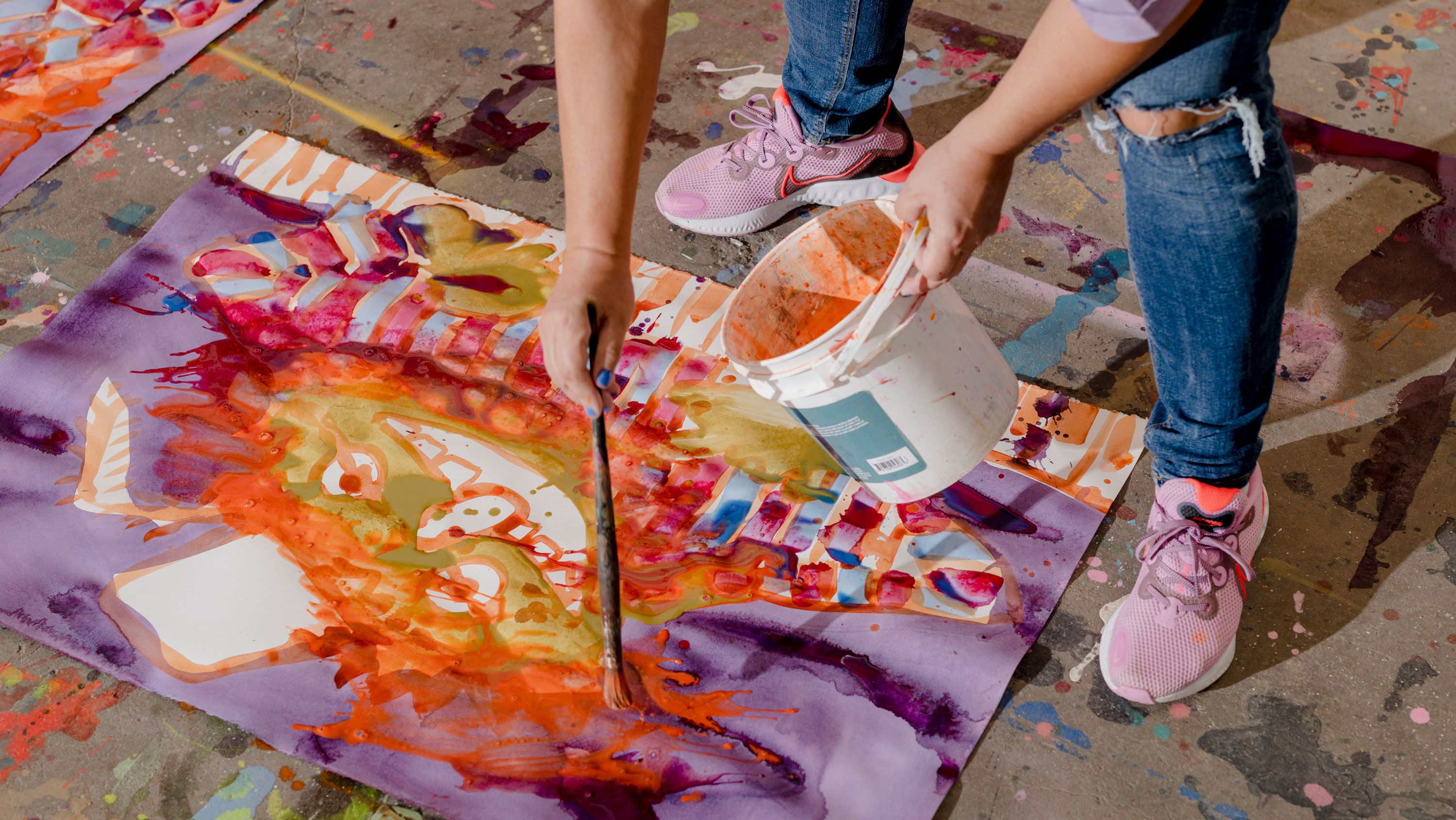 Bernhardt paints with a wet-on-wet process using acrylic mixed with water, moving from canvas to canvas with the same colors