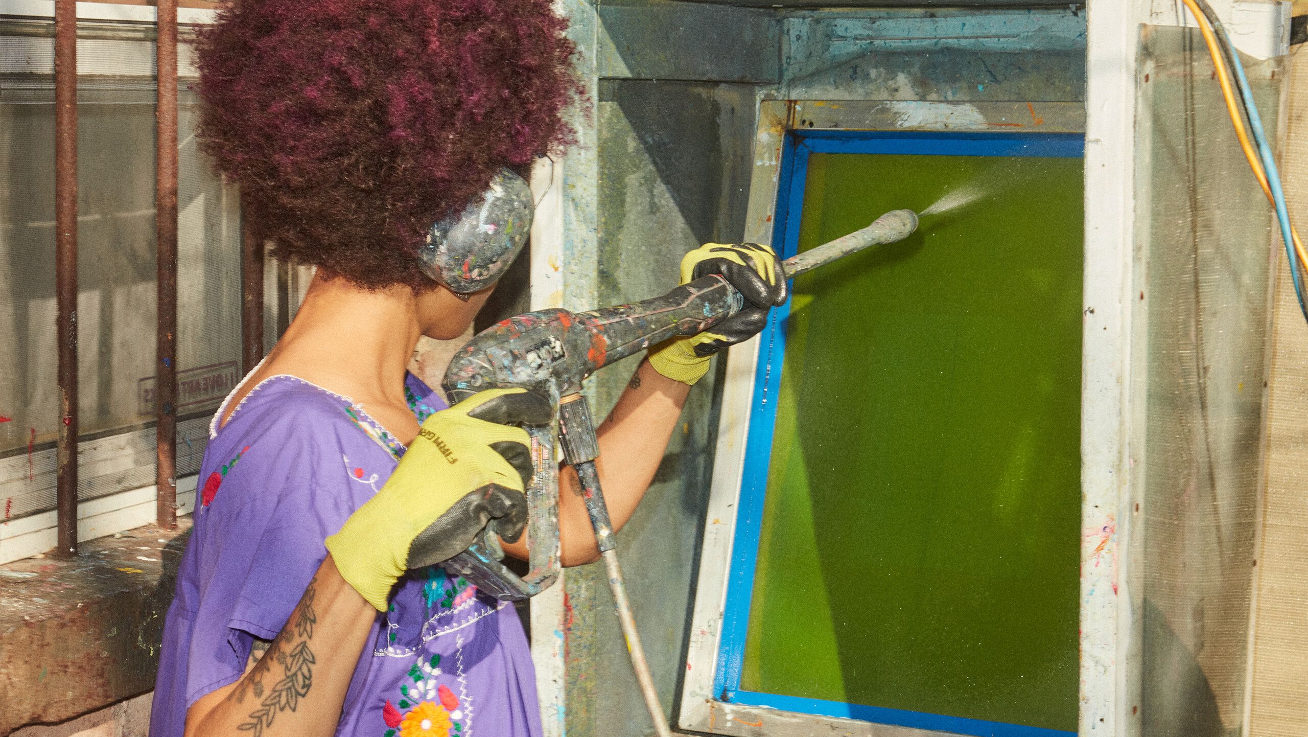 A photograph of Diuguid preparing a screen for printing by Rafael Rios, dated 2022.
