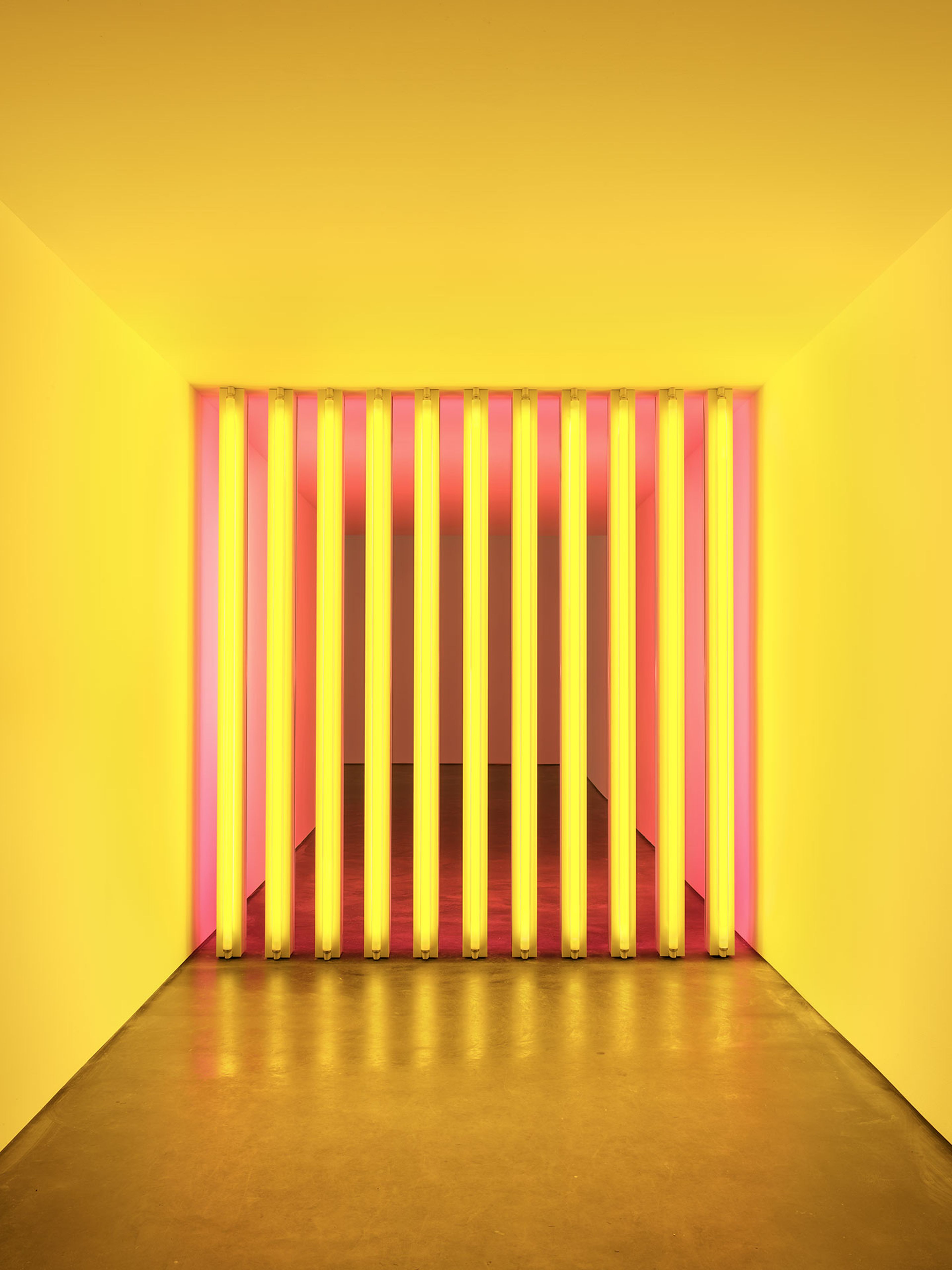 A mid-corridor sculpture in yellow and pink fluorescent light by Dan Flavin, titled untitled (to Barry, Mike, Chuck and Leonard), dated 1972 to 1975.