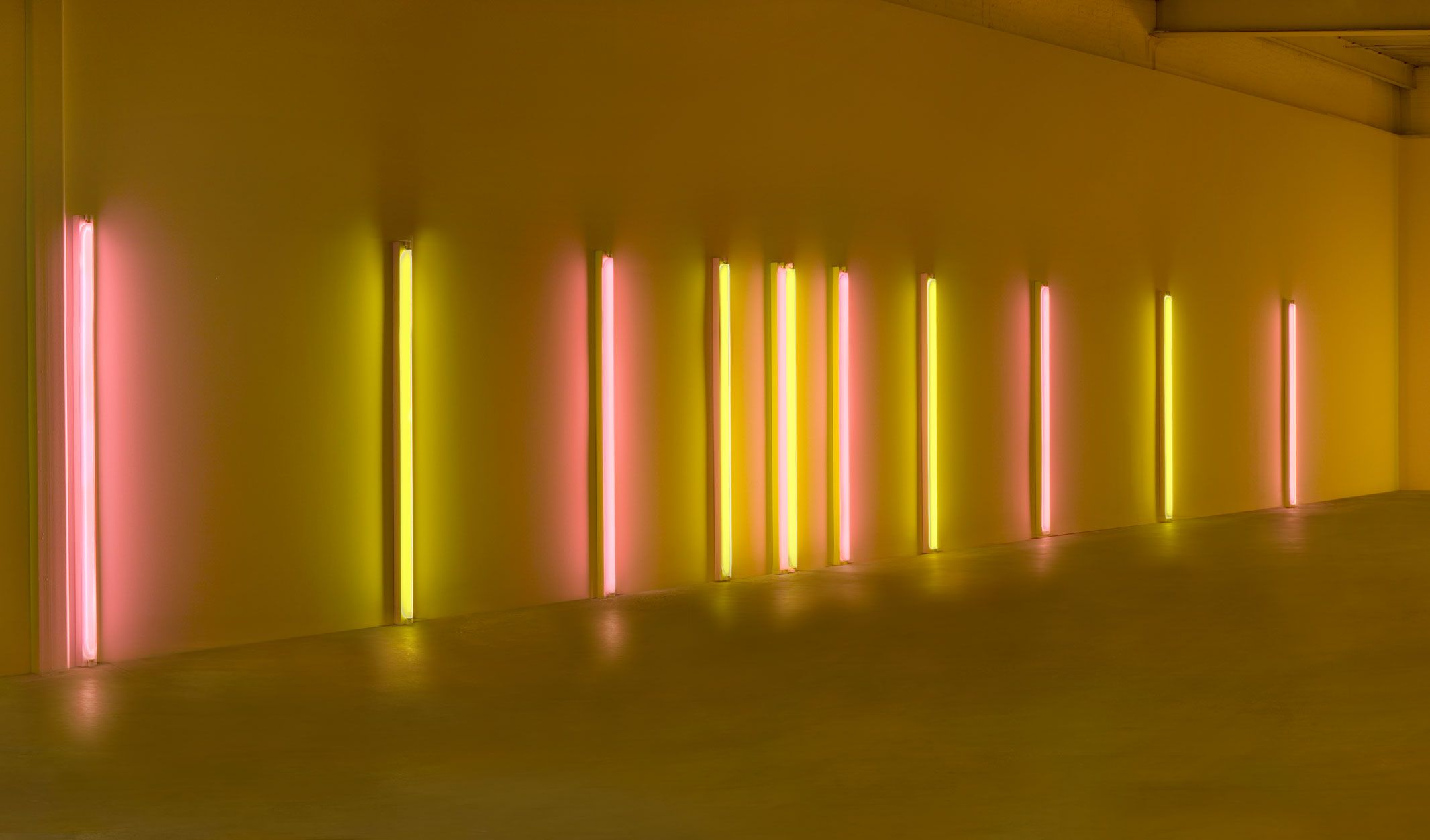 A pink and yellow fluorescent light sculpture by Dan Flavin, titled alternating pink and "gold", dated 1967.
