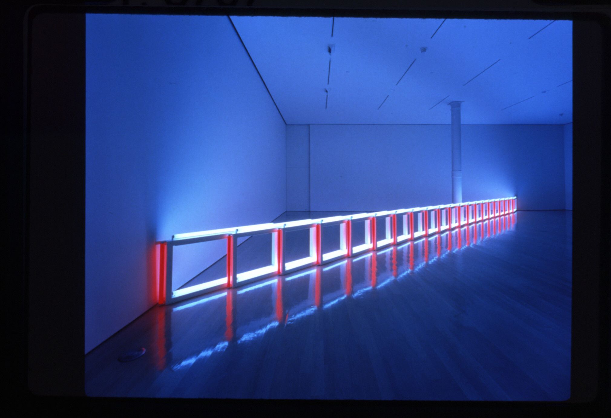 A work by Dan Flavin, titled an artificial barrier of blue, red and blue fluorescent light (to Flavin Starbuck Judd), dated 1968.
