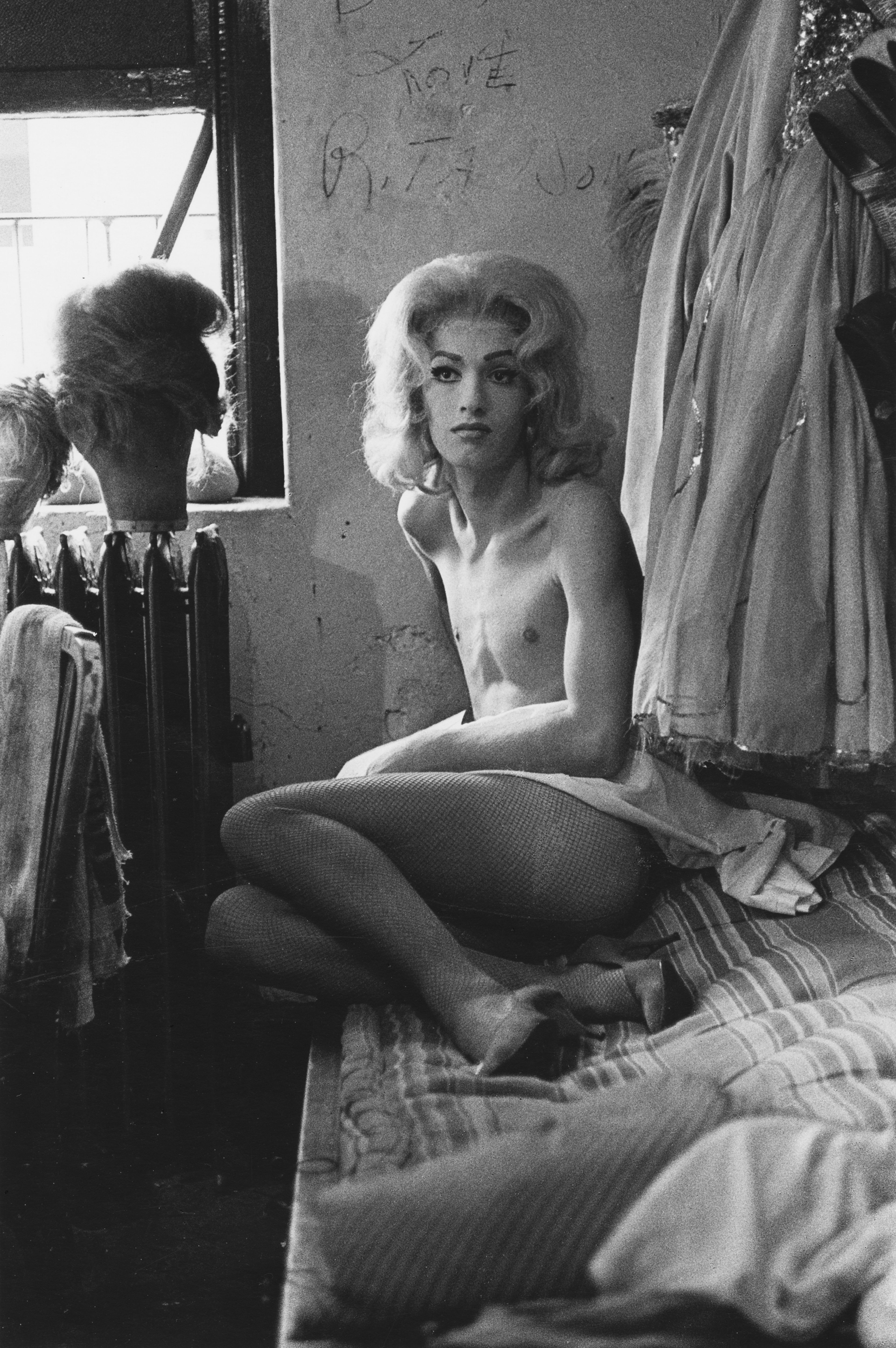 A work titled Female impersonator on bed, N.Y.C. by Diane Arbus, dated 1961