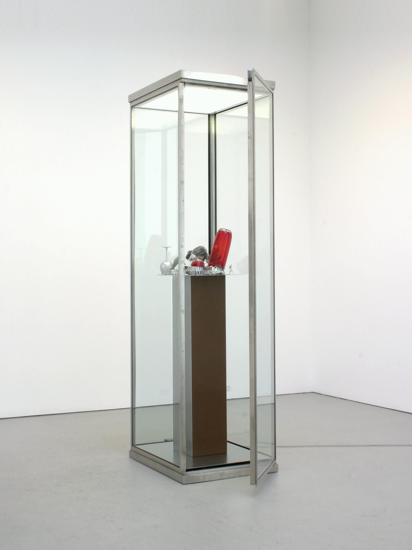 A sculpture by Isa Genzken, titled Vitrine mit rotem Glas, dated 2004.
