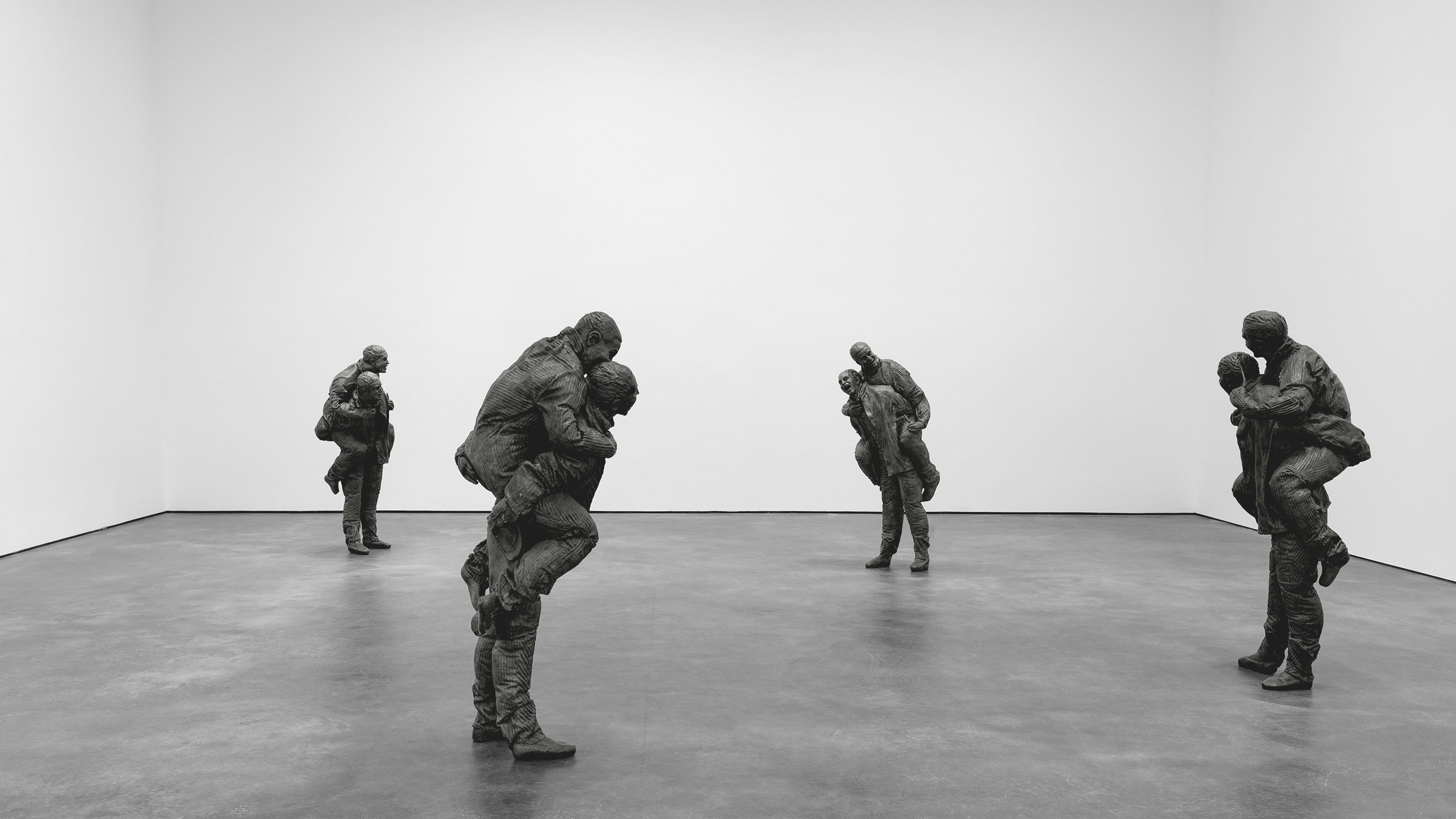 An installation with bronze with grey patina sculptures by Juan Muñoz, titled Four Piggybacks with knives, dated 2001.