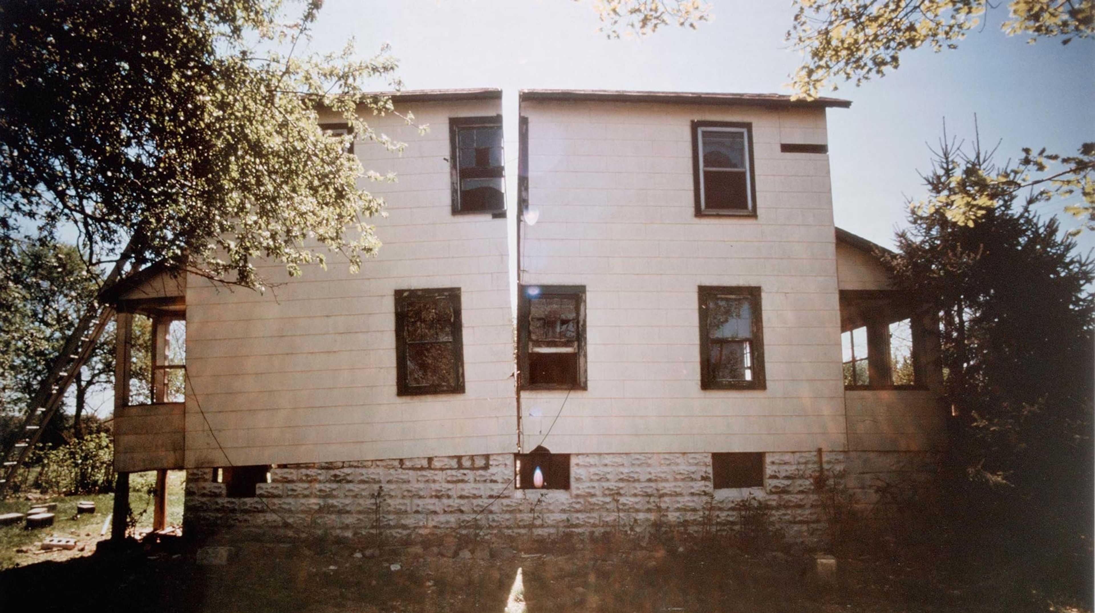 A photo of an artwork by Gordon Matta-Clark, titled Splitting, dated 1974.