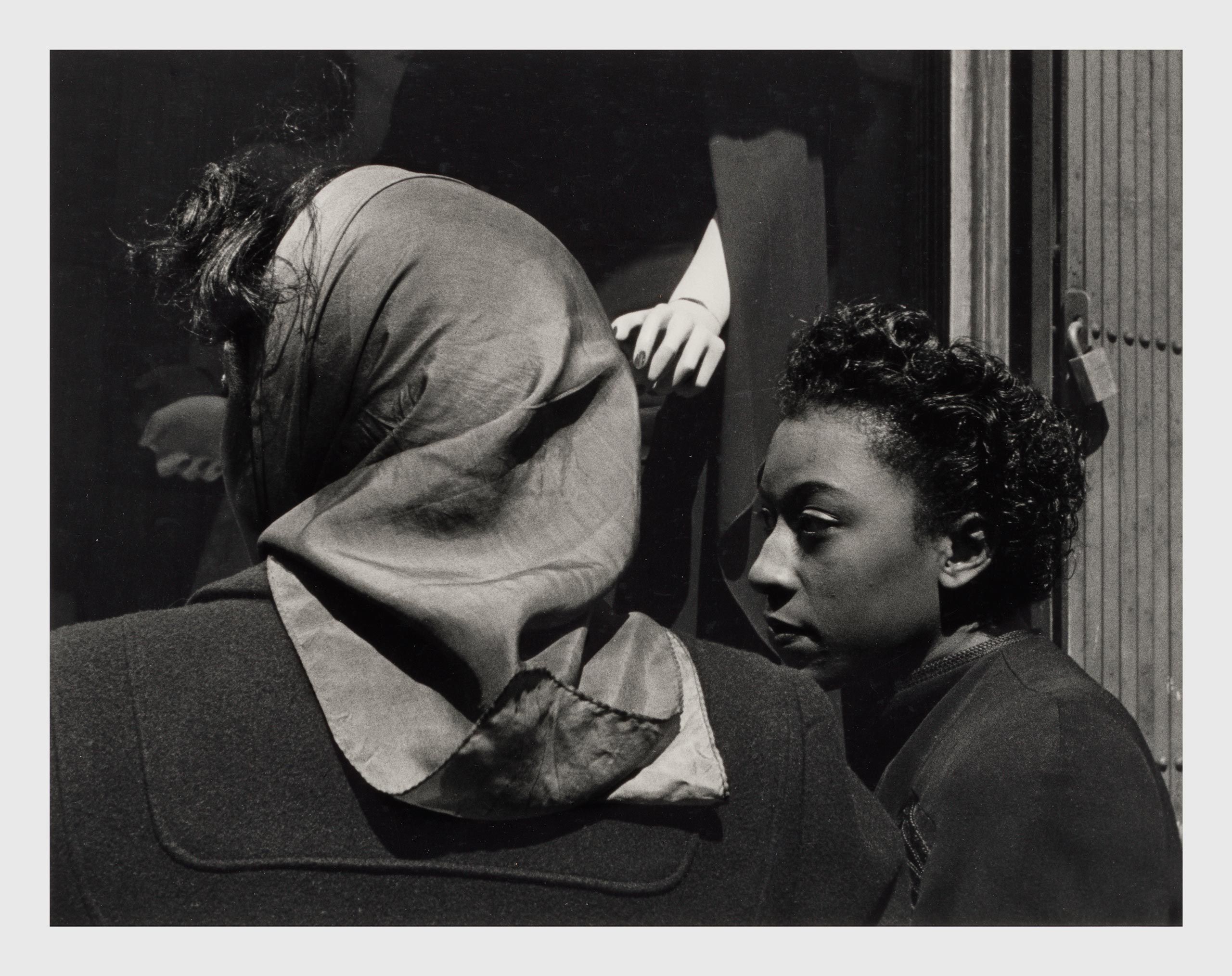 A Silver gelatin print by Roy DeCarava, titled Two women, mannequin's hand, dated 1952.