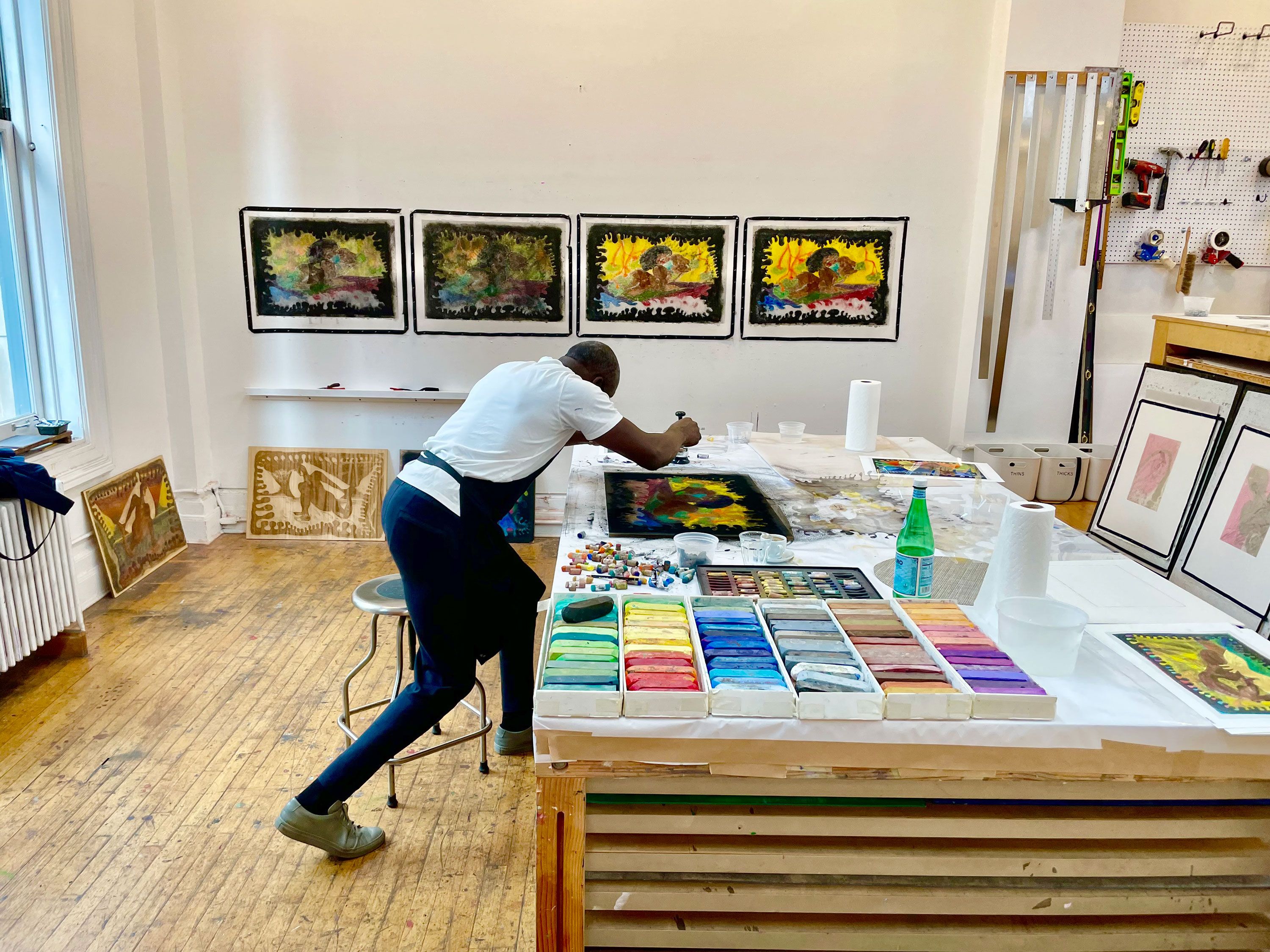 Chris Ofili pressing print in studio, 2021
