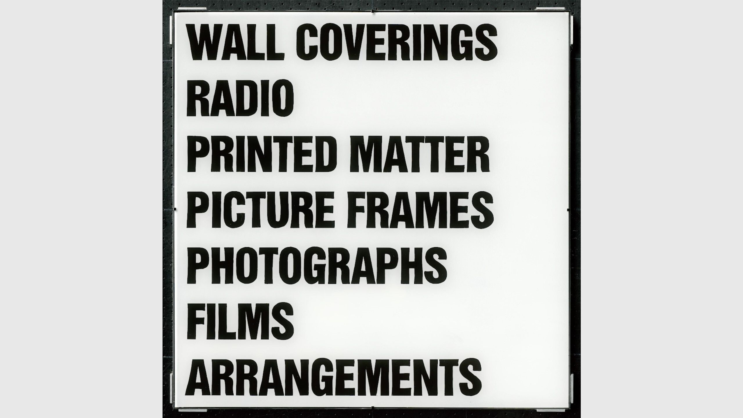 A video by Christopher Williams, titled Provisional Prop, Wall Coverings, Radio, Printed Matter, Picture Frames, Photographs, Films, Arrangements, dated 2021.