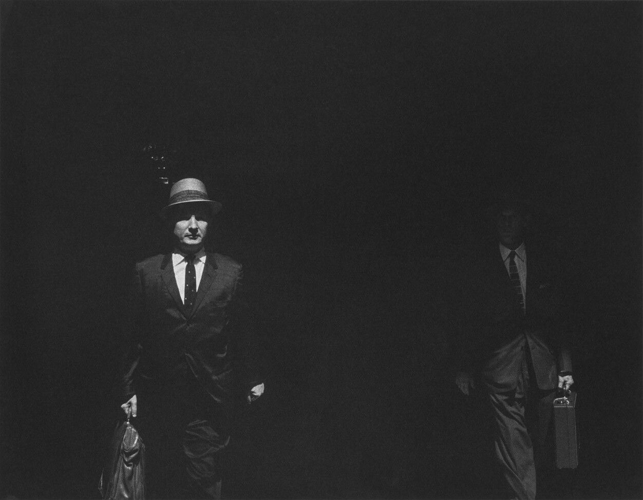 A silver gelatin print by Roy DeCarava, titled Men walking from shade, 1961.