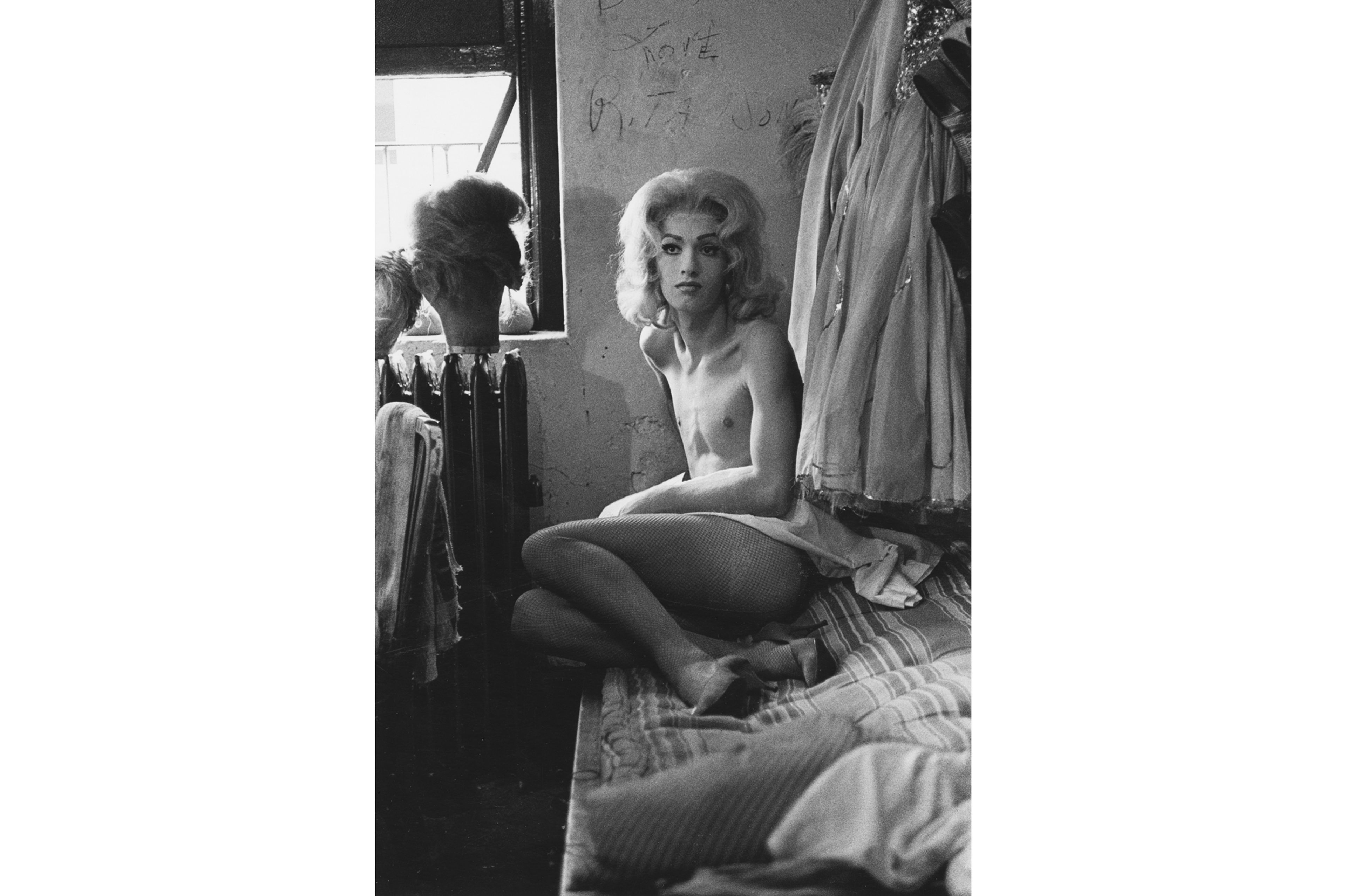 A work titled Female impersonator on bed, N.Y.C. by Diane Arbus, dated 1961