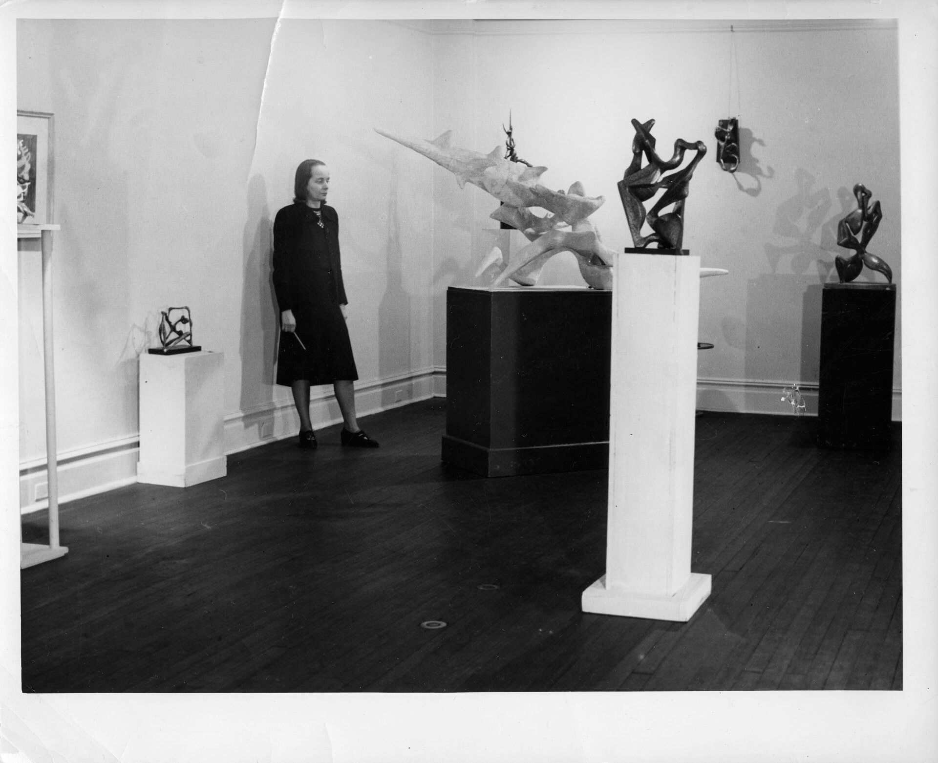 Betty Parsons standing in the installation of Herbert Ferber, Betty Parsons Gallery, New York, circa 1947 to 1948.