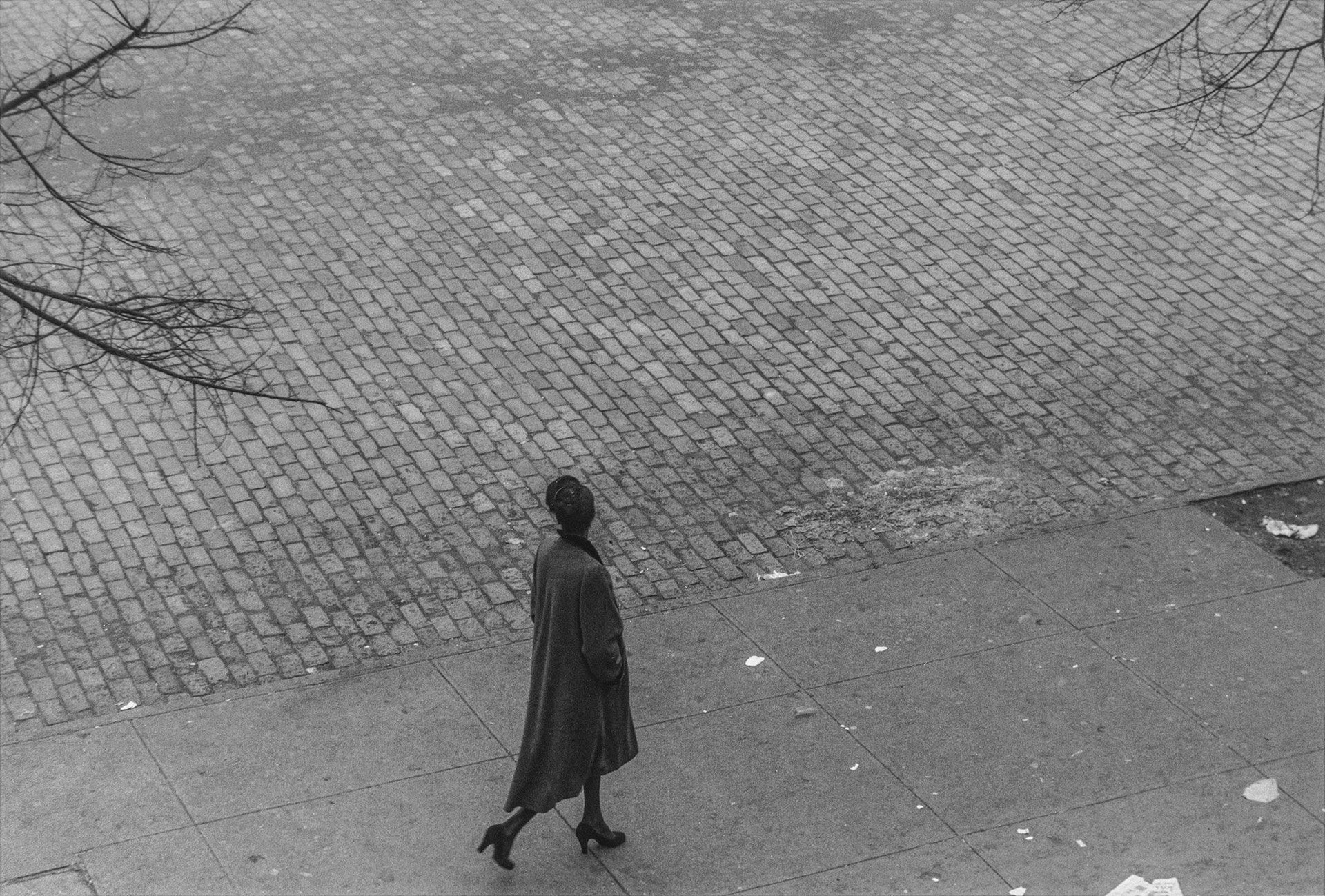 A silver gelatin print by Roy DeCarava, titled Woman walking above, dated 1950.