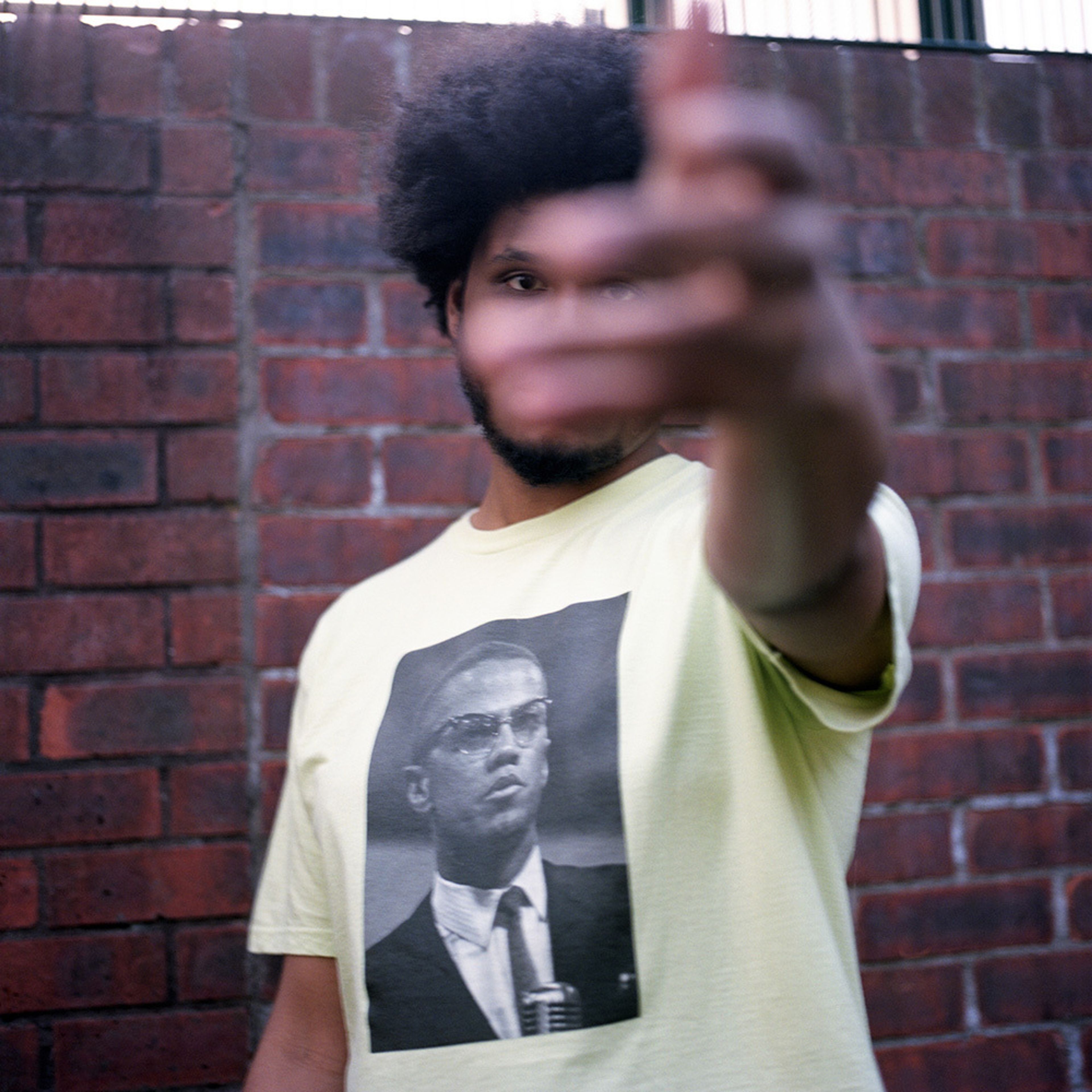 A photograph of a T-shirt by Supreme being worn by a model, featuring a photograph by Roy DeCarava.