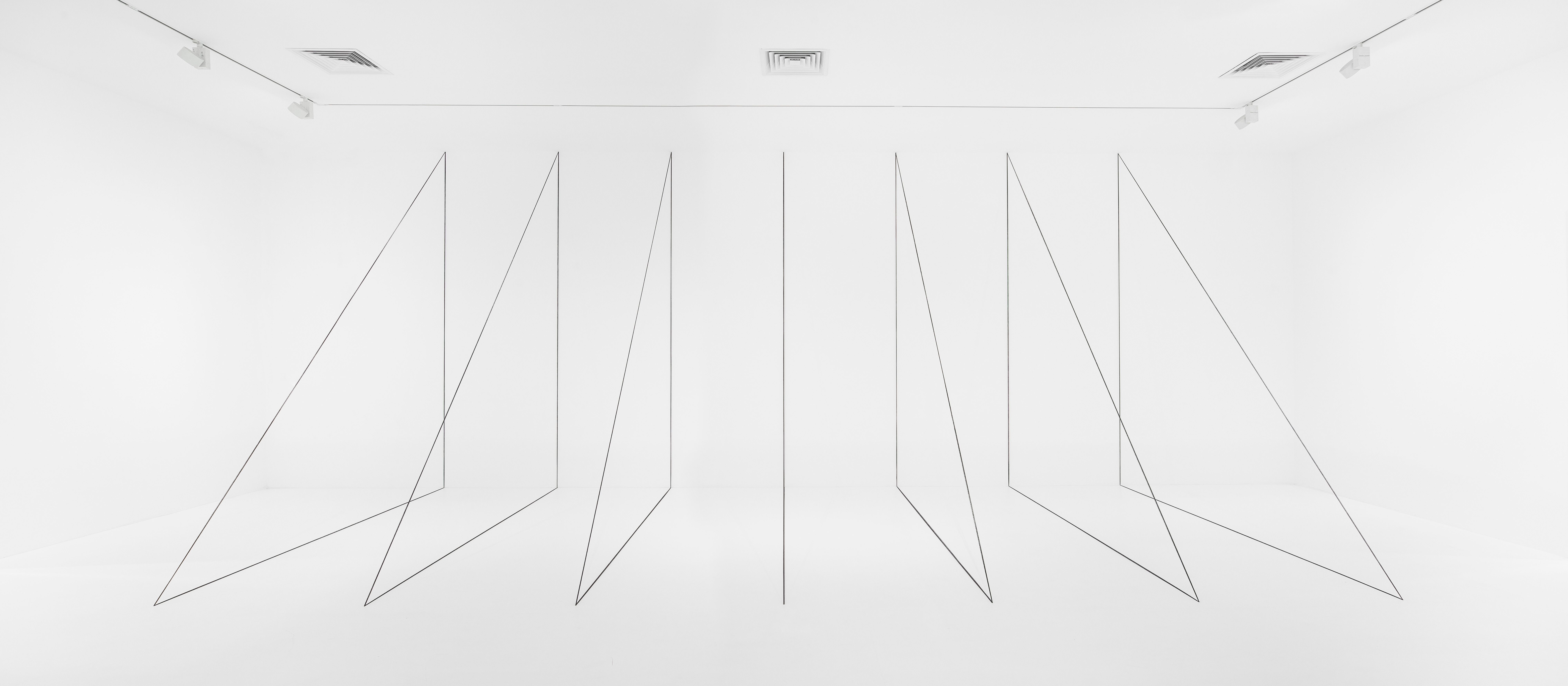An installation view of a work by Fred Sandback, called Untitled (Sculptural Study, Swcen-part Right-angled Triangular Construction), dated 1982/2010.