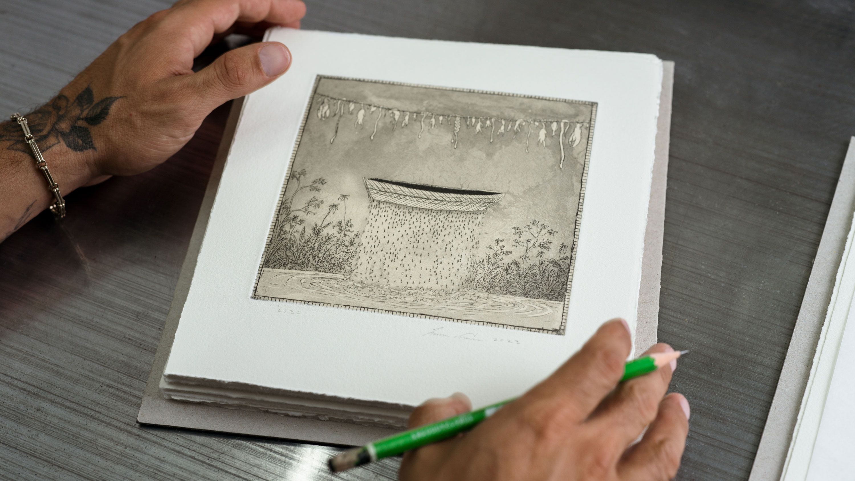 A photo of Arruda signing each diptych