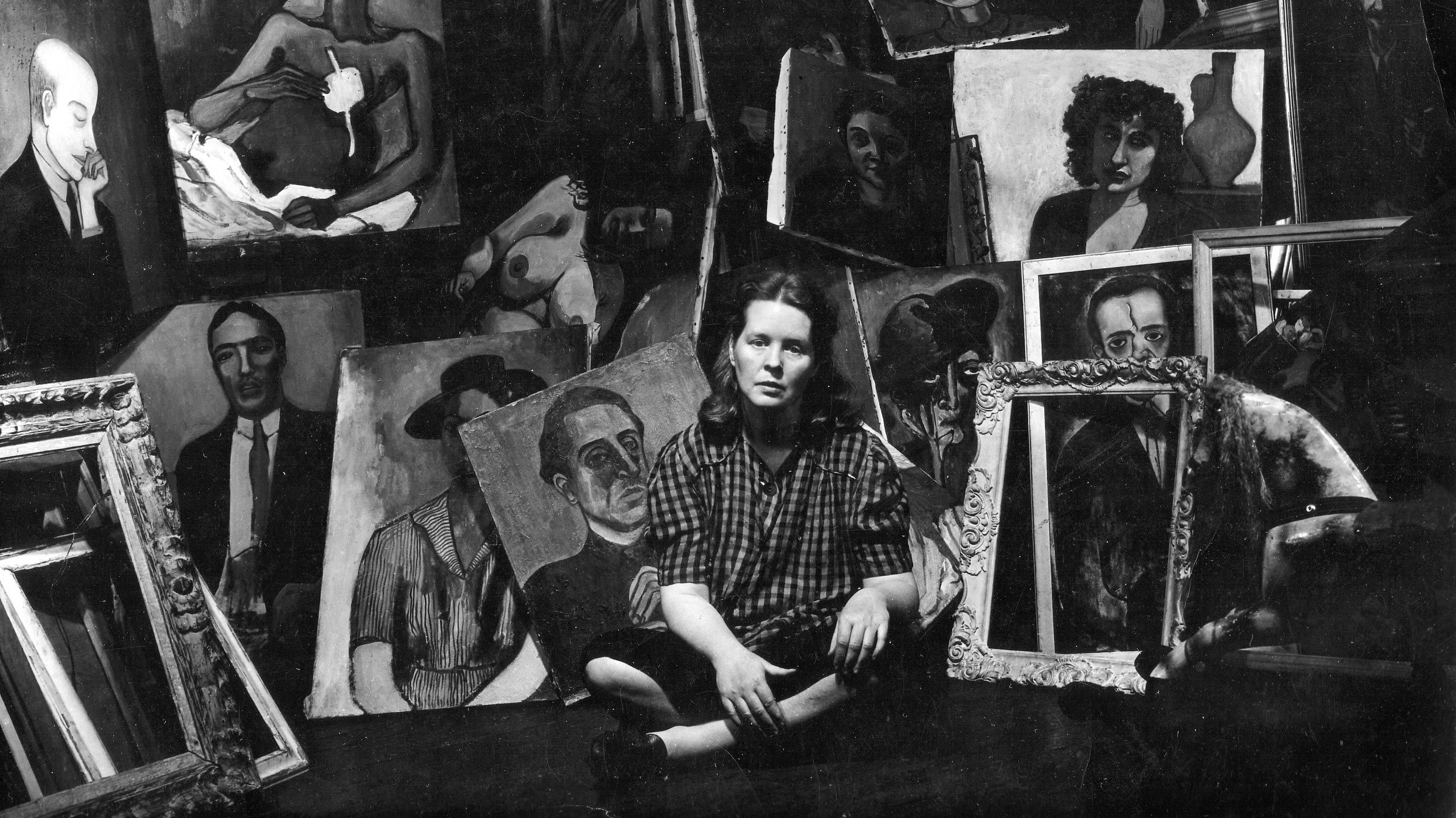 A photo of Alice Neel with her paintings.