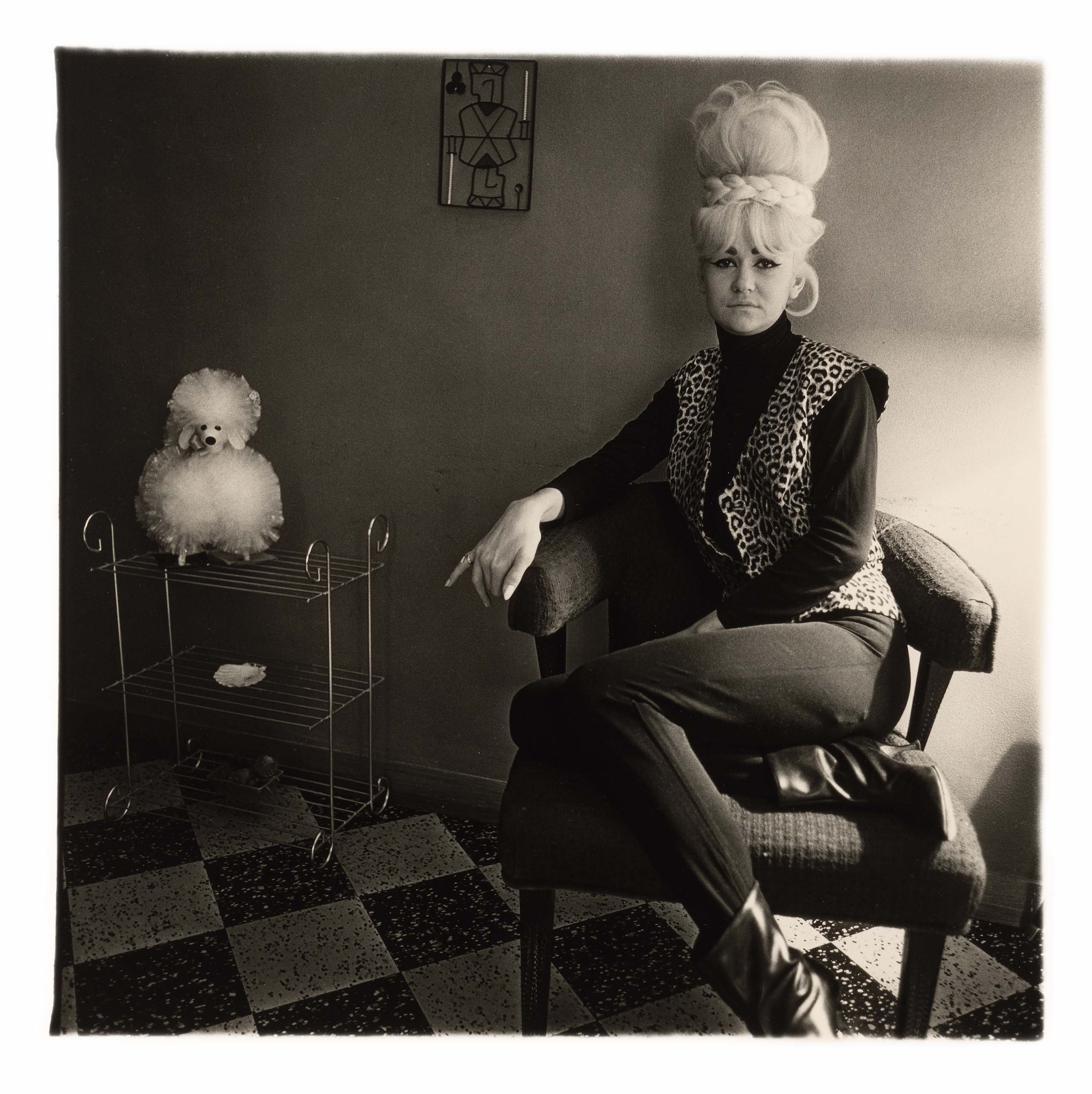 A gelatin silver print by Diane Arbus, titled Lady bartender at home with a souvenir dog, New Orleans, La. 1964, dated 1964.