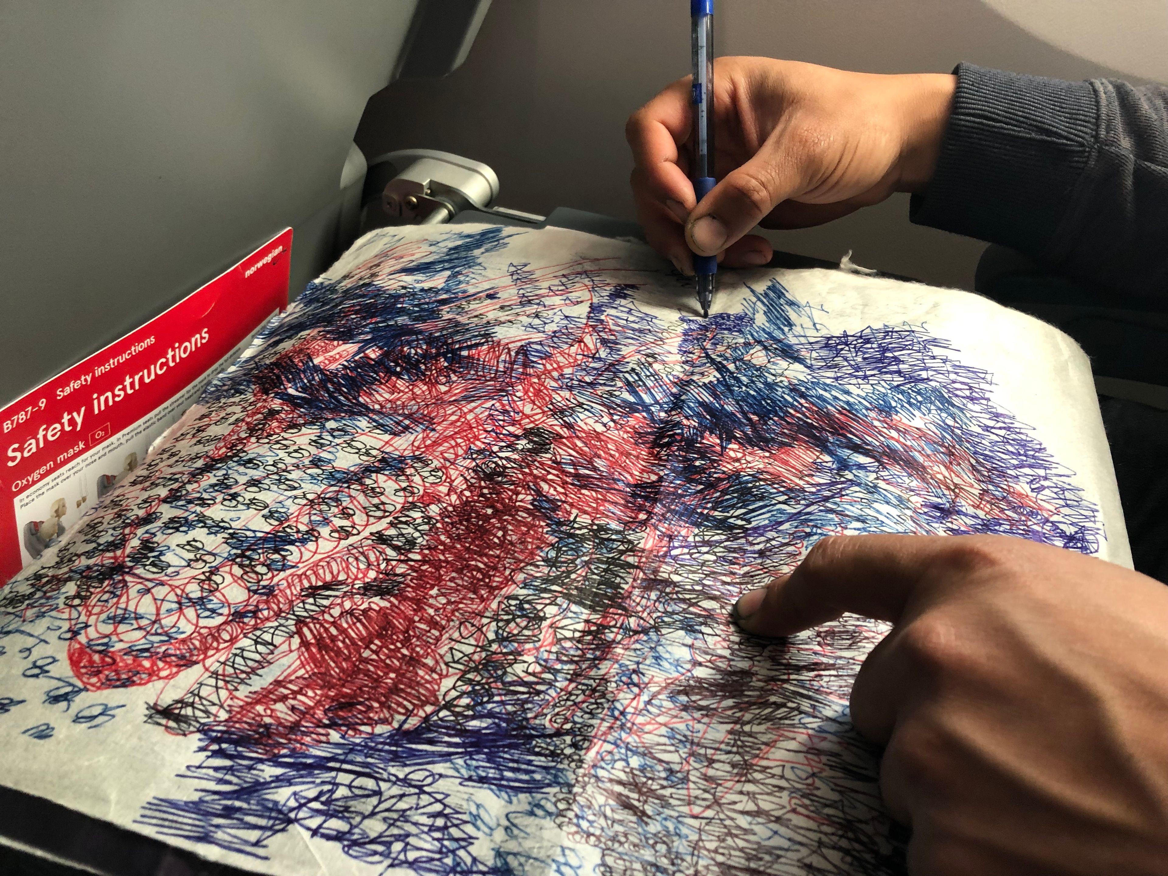 A photo of Oscar Murillo drawing in flight