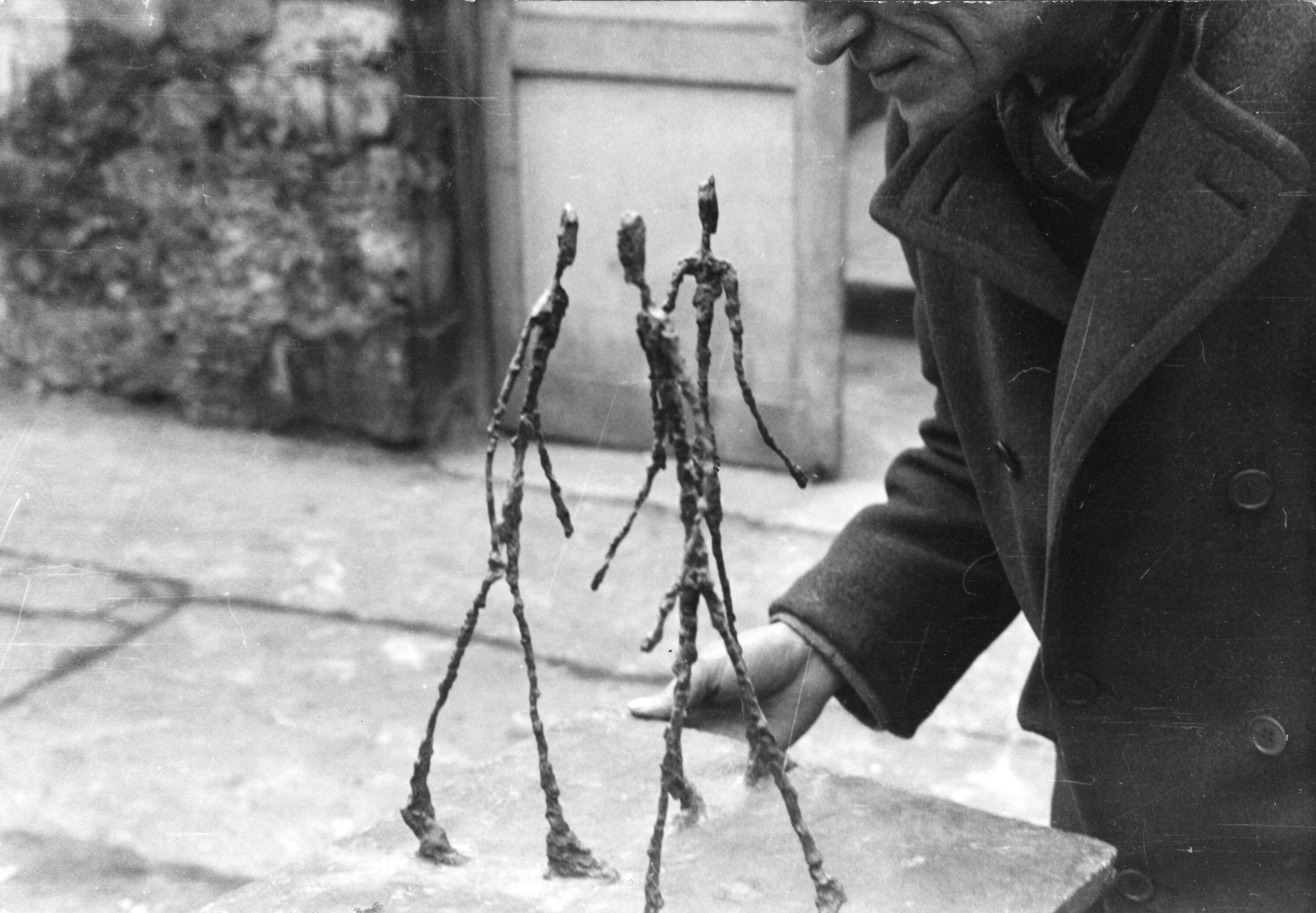 Anonymous, Alberto Giacometti holding Three Men Walking I, dated 1948