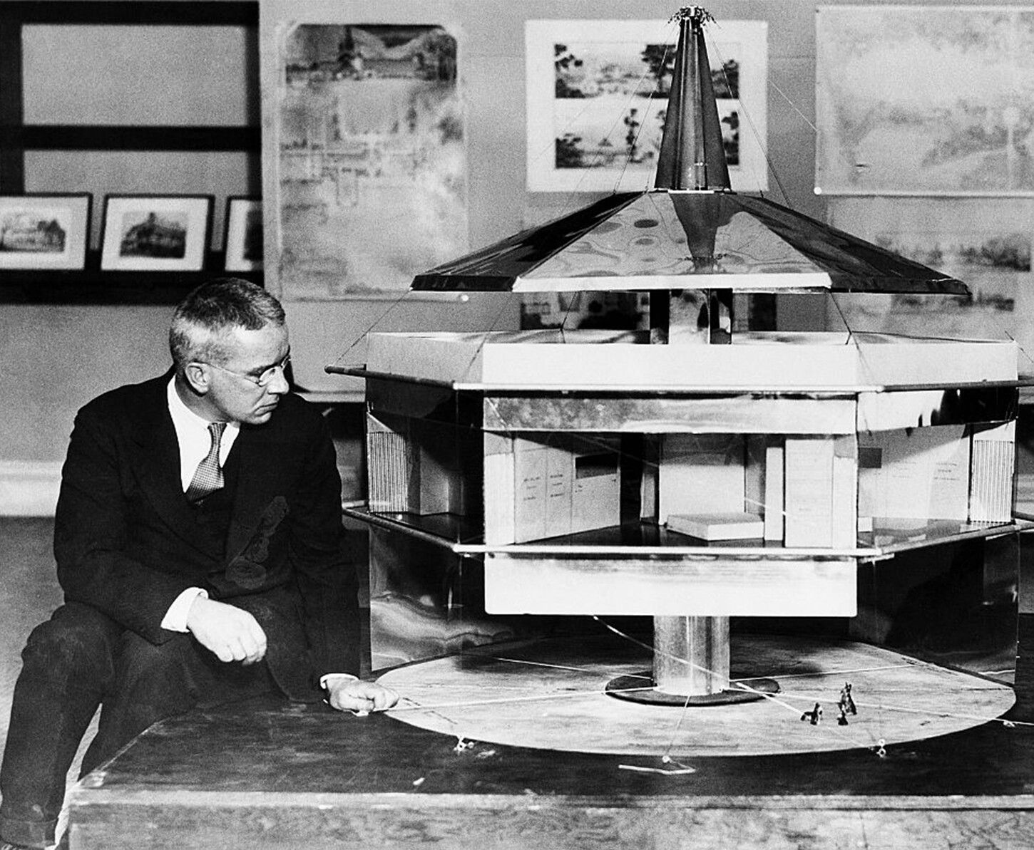 A photo of Buckminster Fuller next to a model of his Dymaxion house.