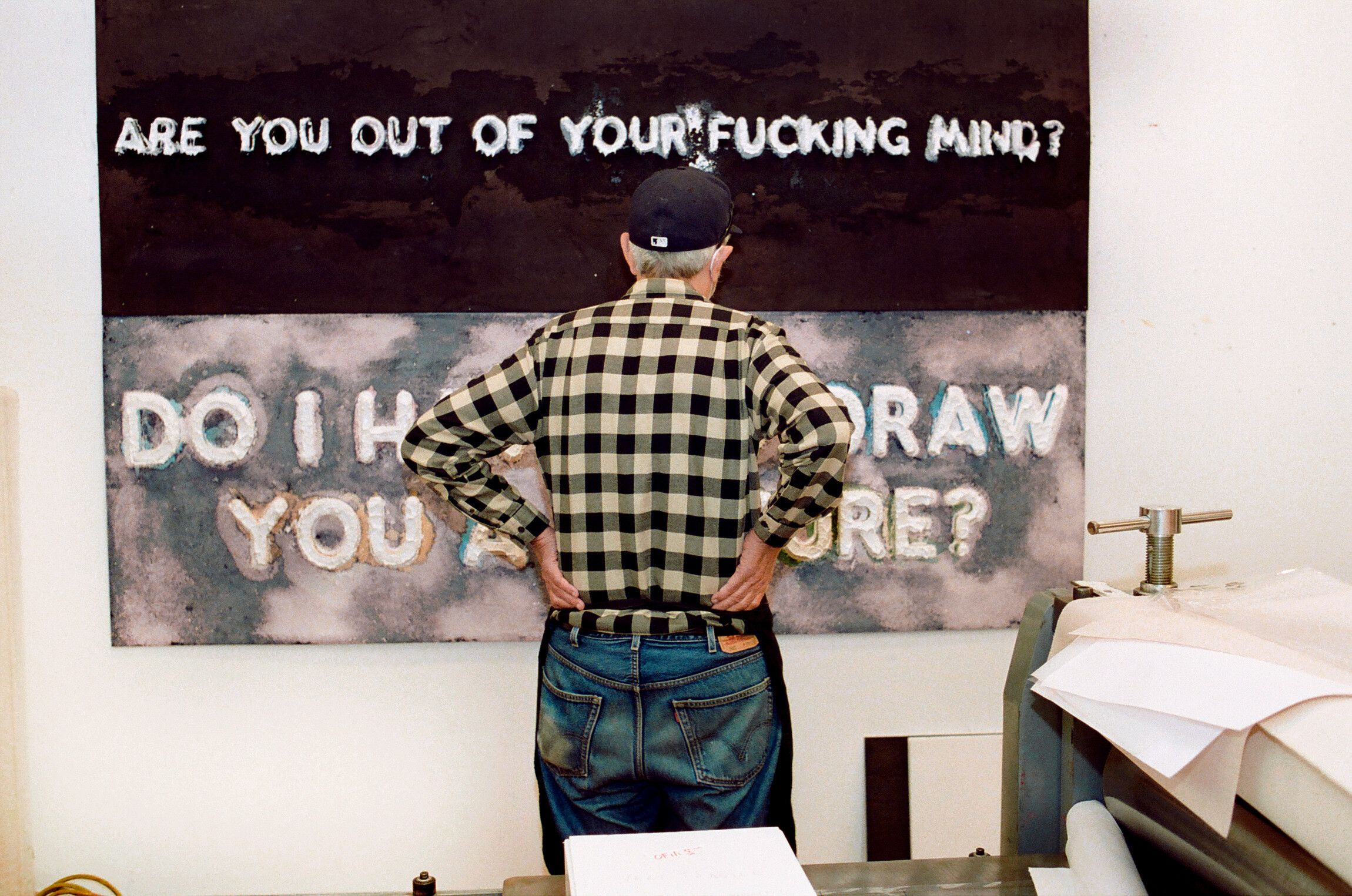Artist looking at a print in studio, 2021