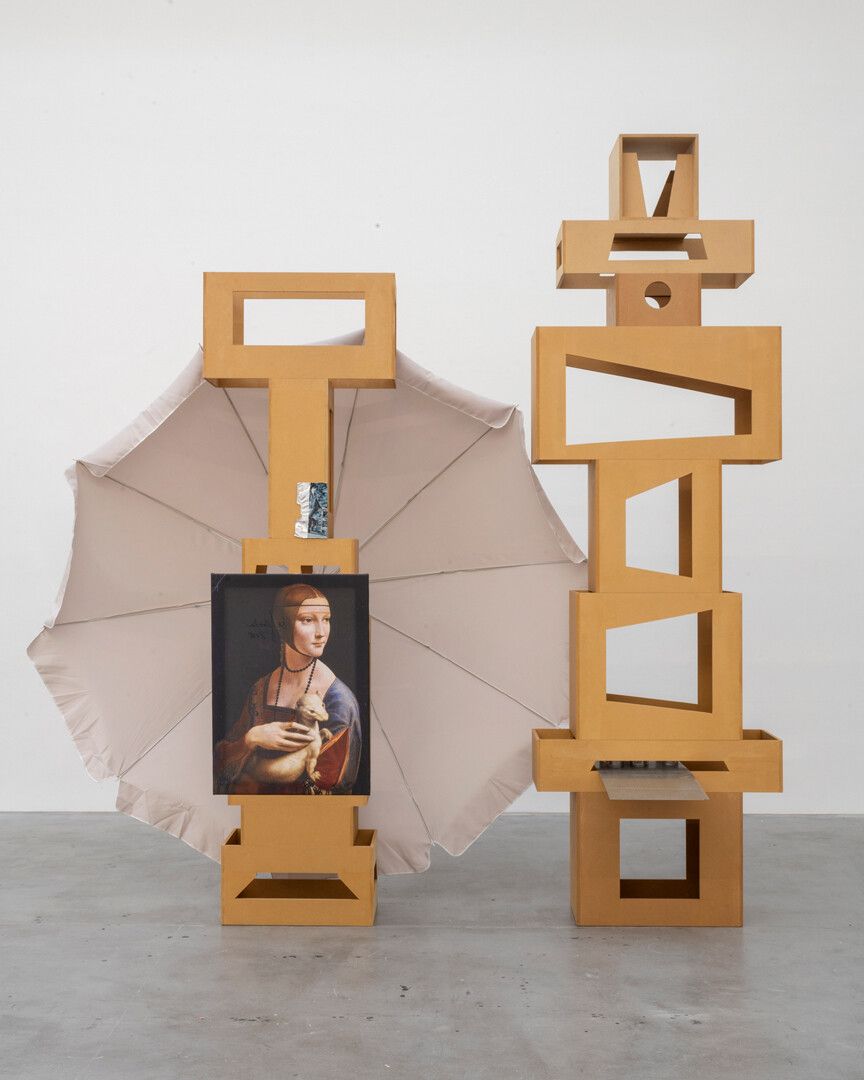 An untitled MDF towers, print on canvas, spray can, metal grill, parasol, aluminum foil tape, and flyer sculpture by Isa Genzken, dated 2018.